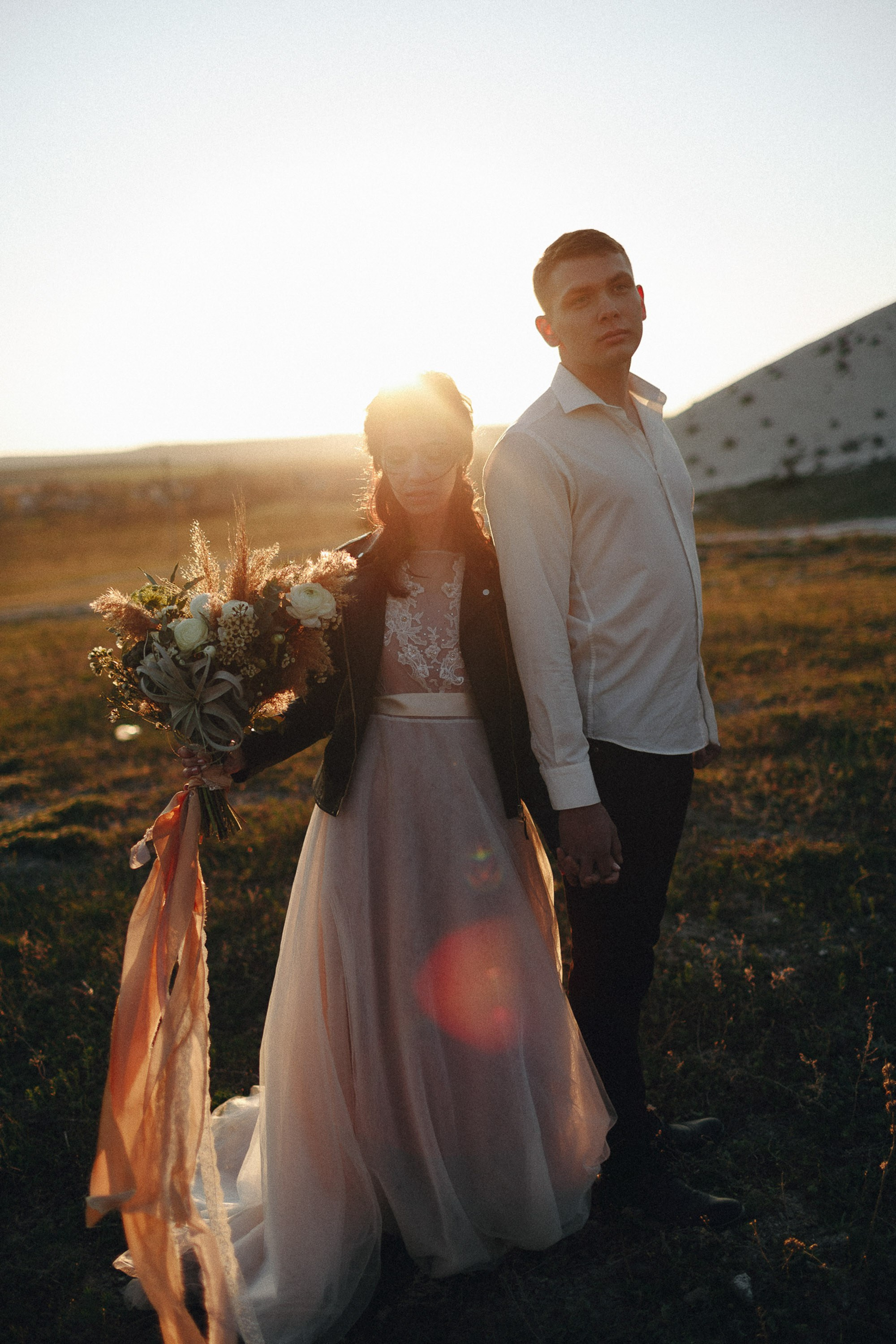 Bride and groom walking at sunset, outdoor wedding