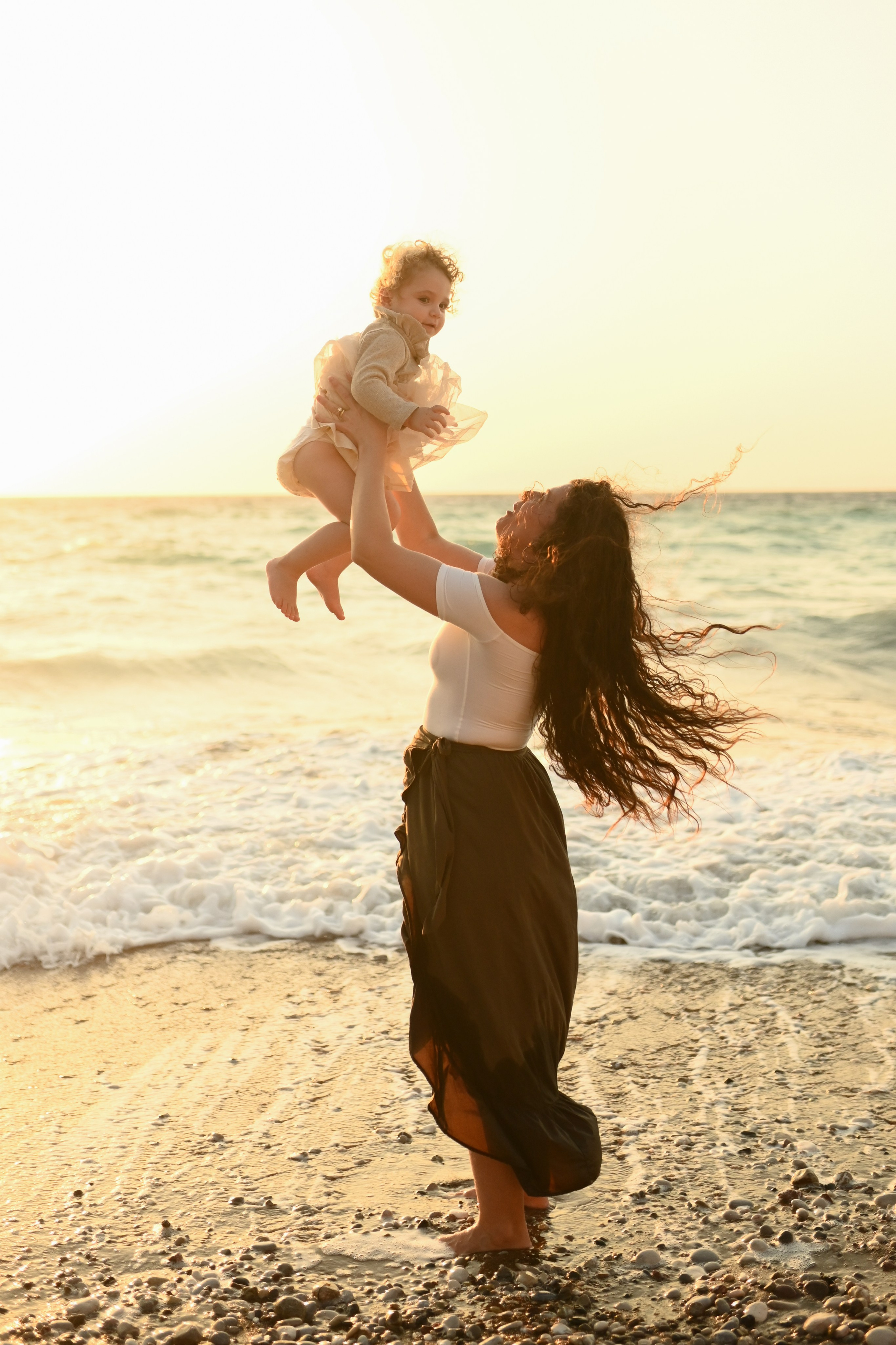 Happy family walking along a Rhodes beach at sunset. Photographer in Rhodes Island