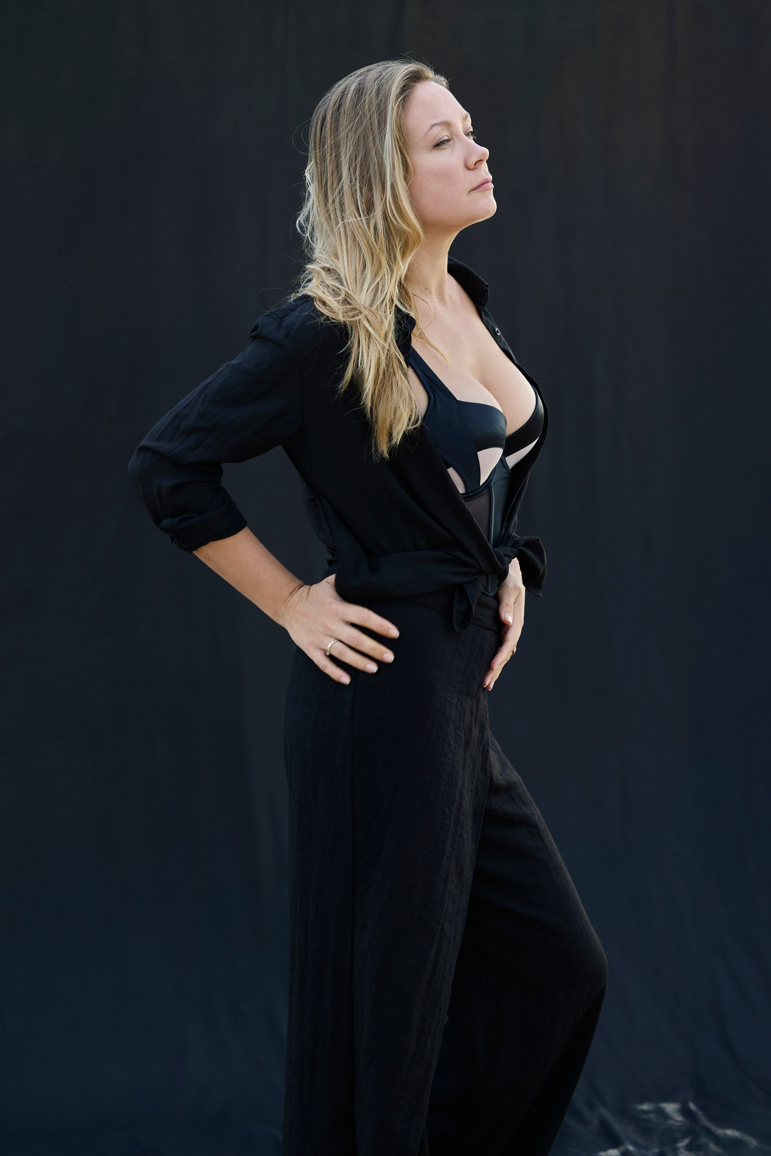 Retrato elegante de mujer con vestido negro sobre fondo oscuro en Valencia
