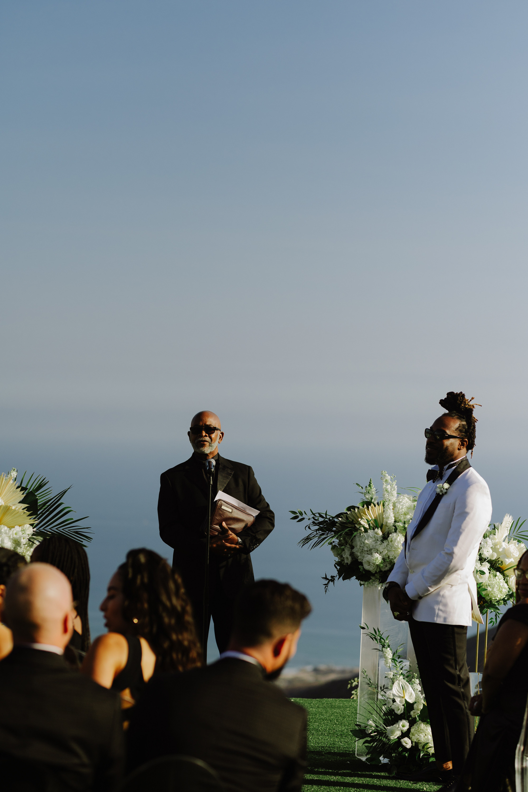 a man in a suit and tie standing at a wedding ceremony