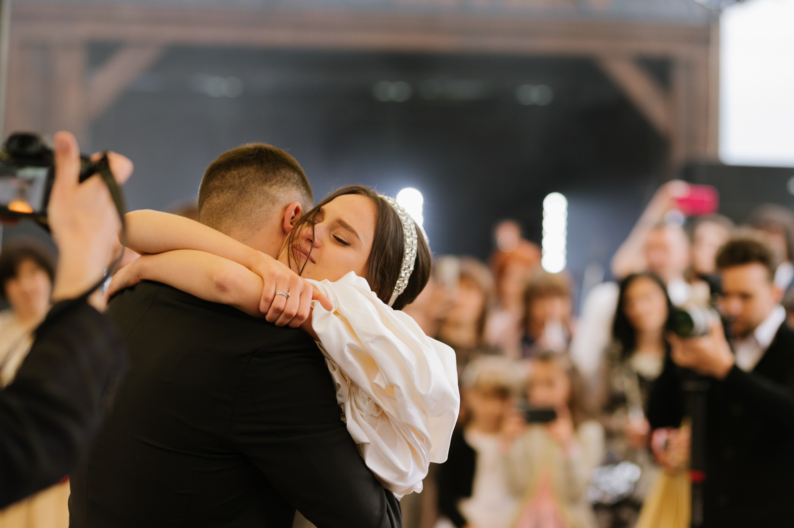a couple hugging each other people at a wedding