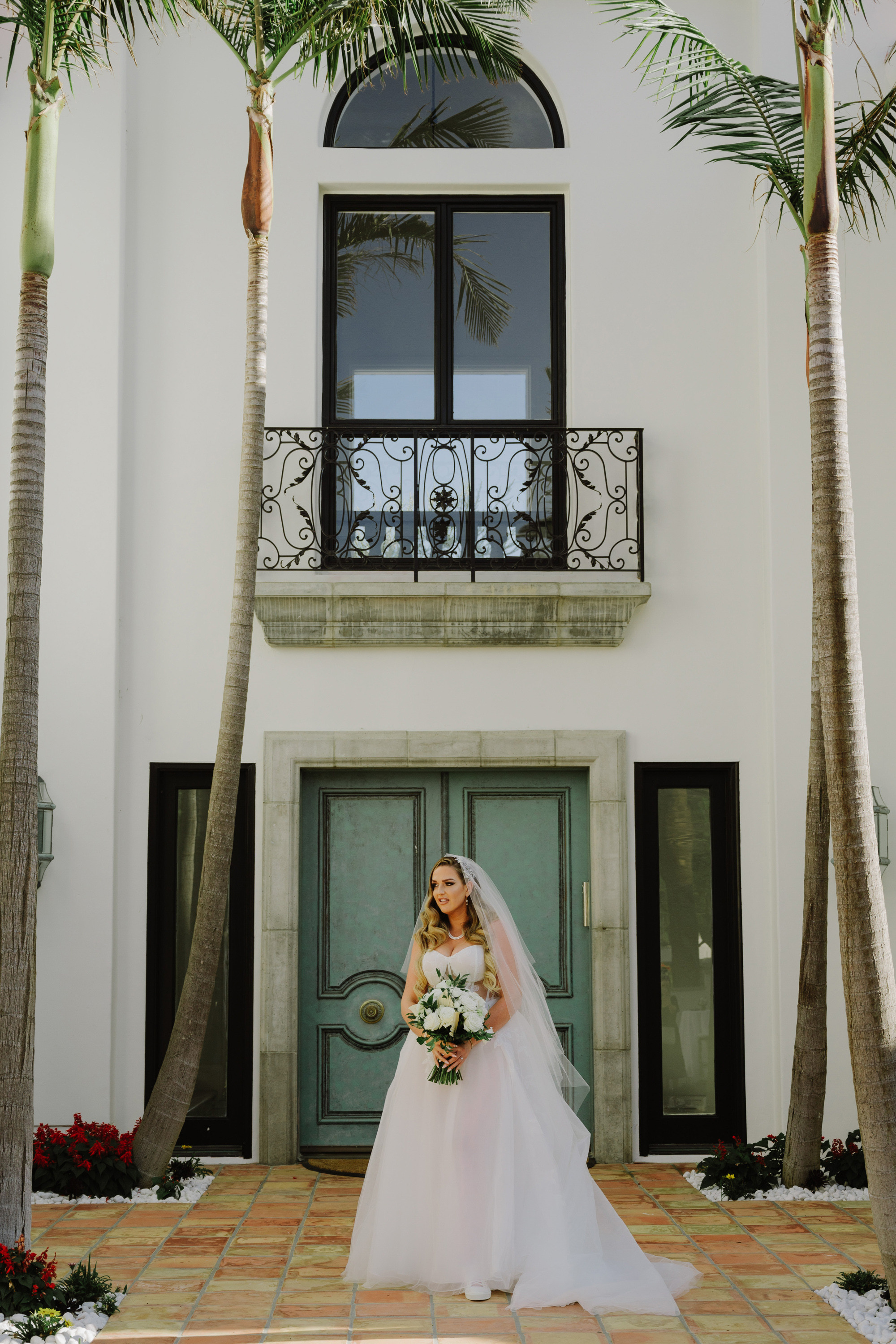 a bride standing in front of a palm tree