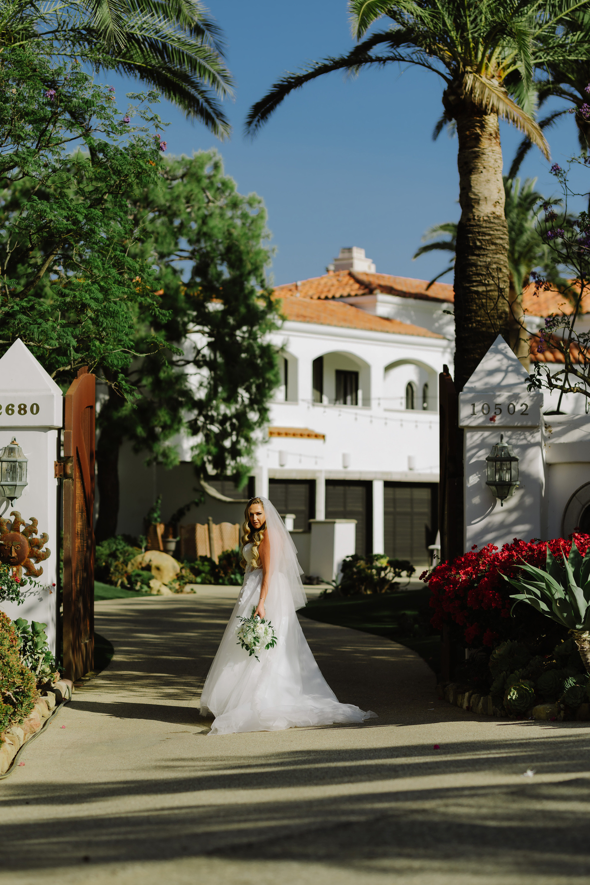 a bride in a white dress walking down a street