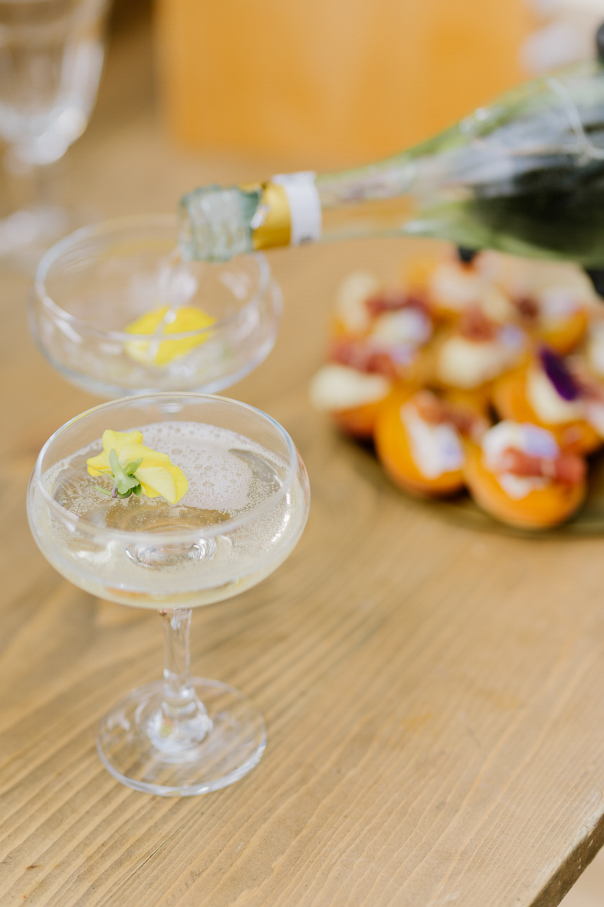 a table with a glass of cocktail and a plate of food