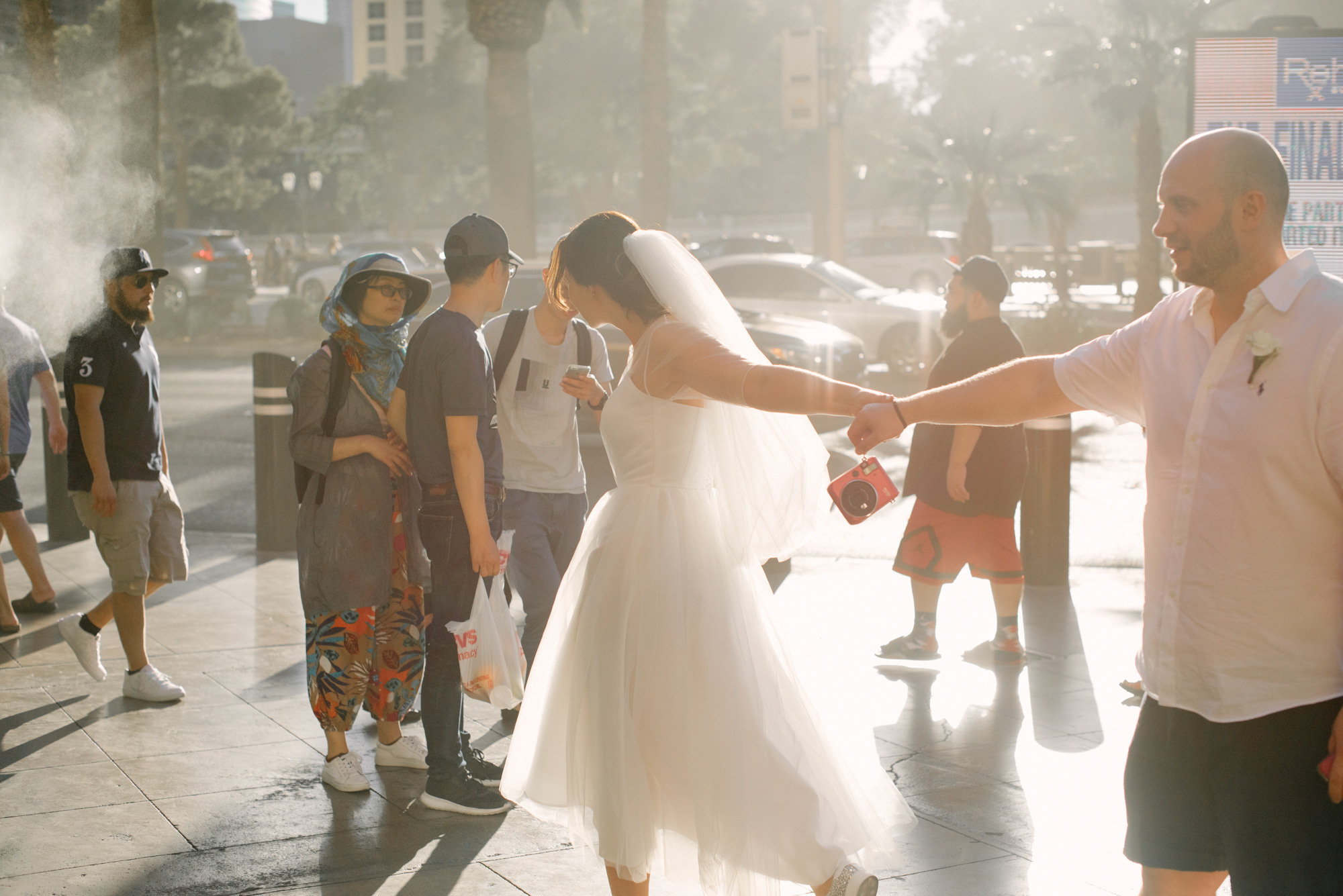 a bride and groom dancing on the street
