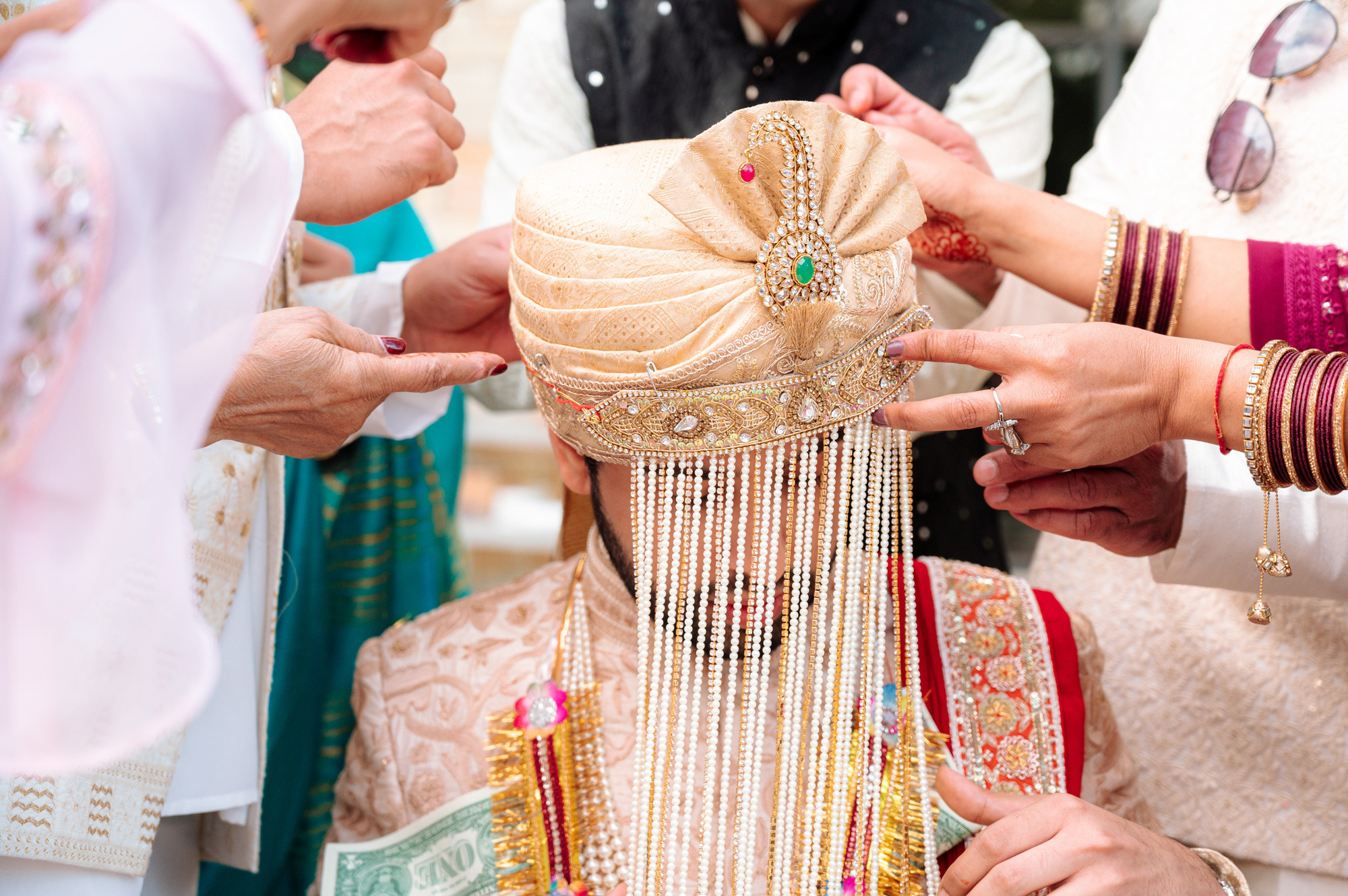 a group of people putting a necklace on a woman