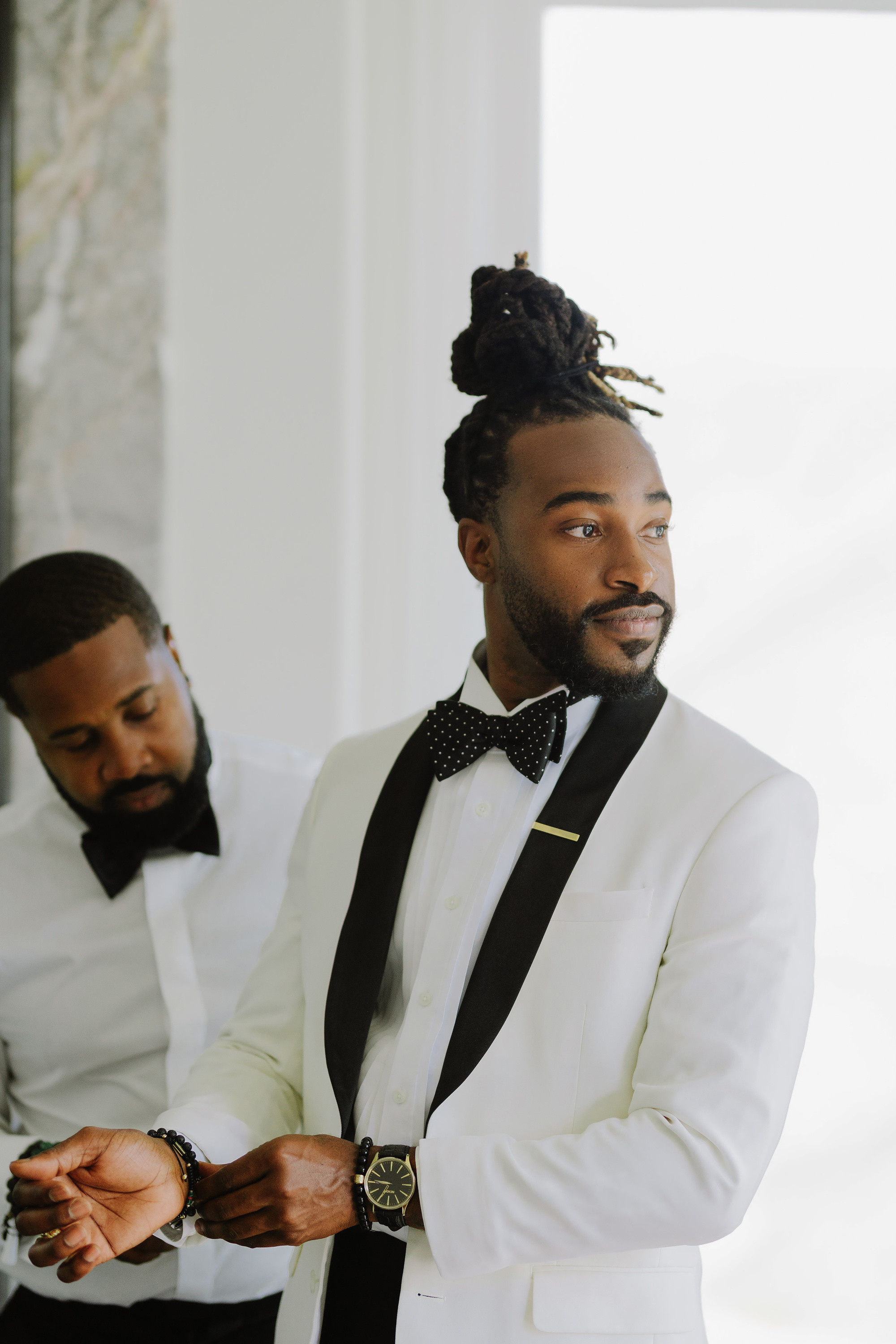 a man in a white suit and bow tie