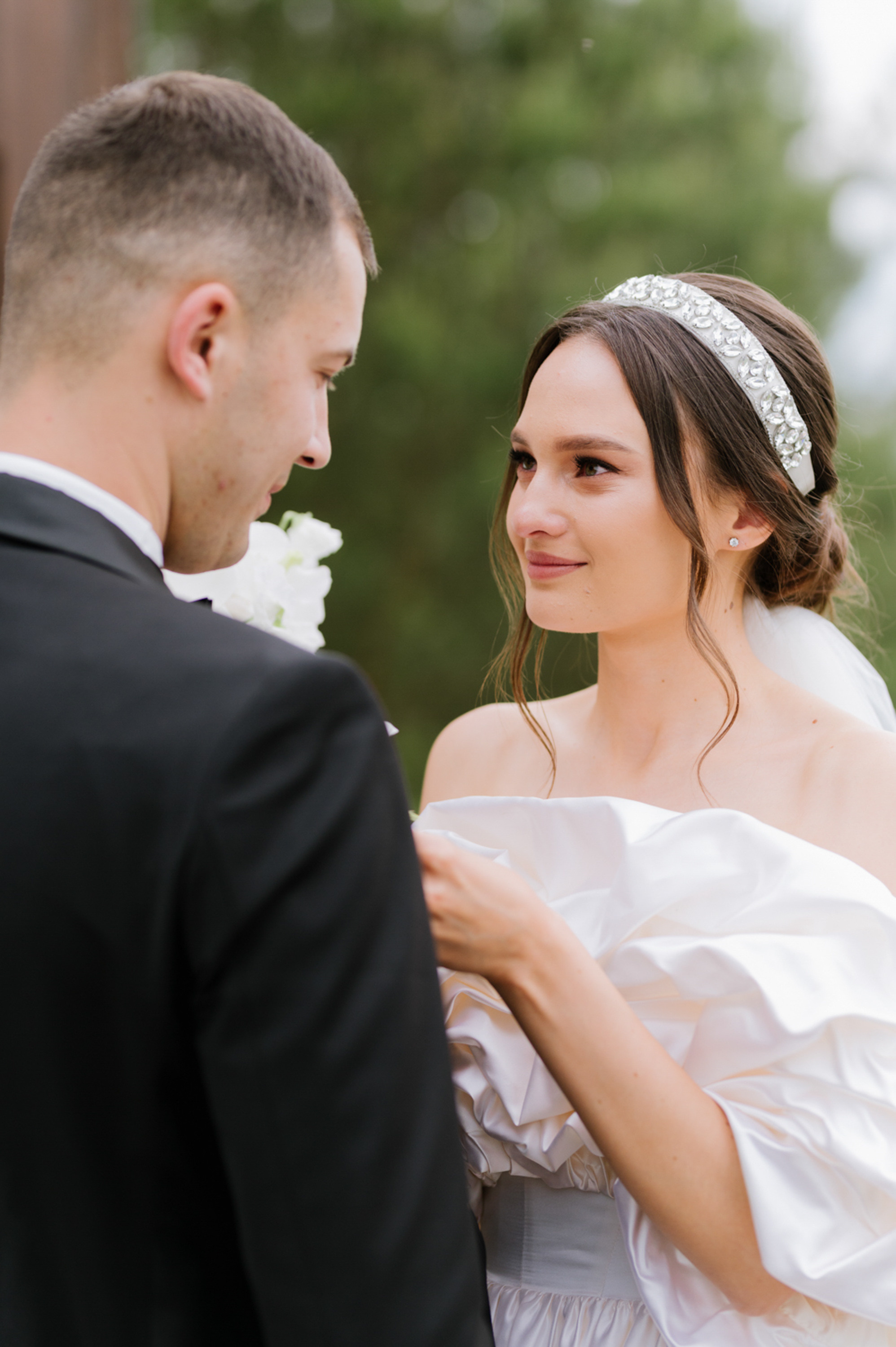 a bride and groom are looking at each other people