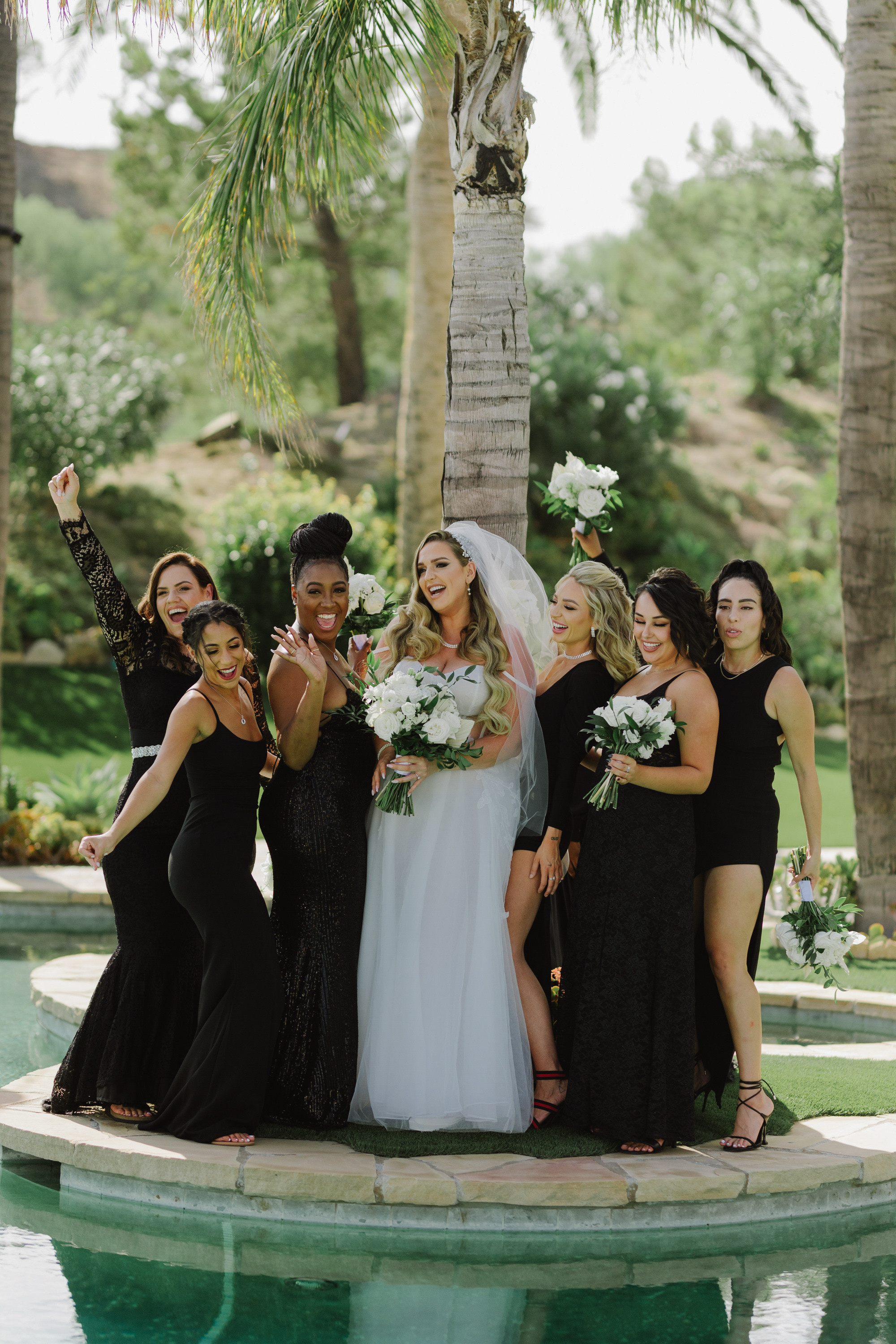 a bride and her bridesmas pose for a photo in front of a pool