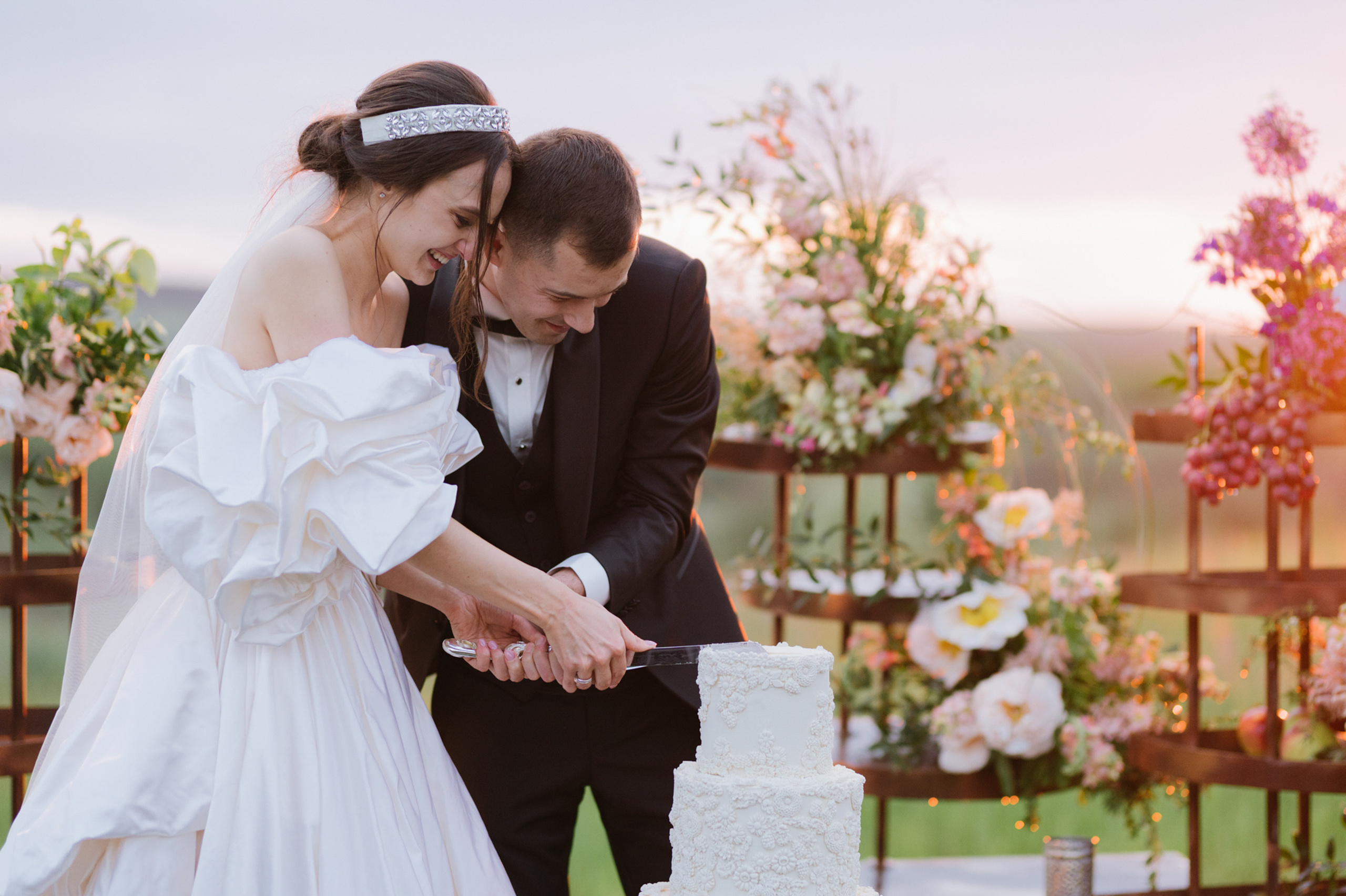 a bride and groom cutting a wedding cake