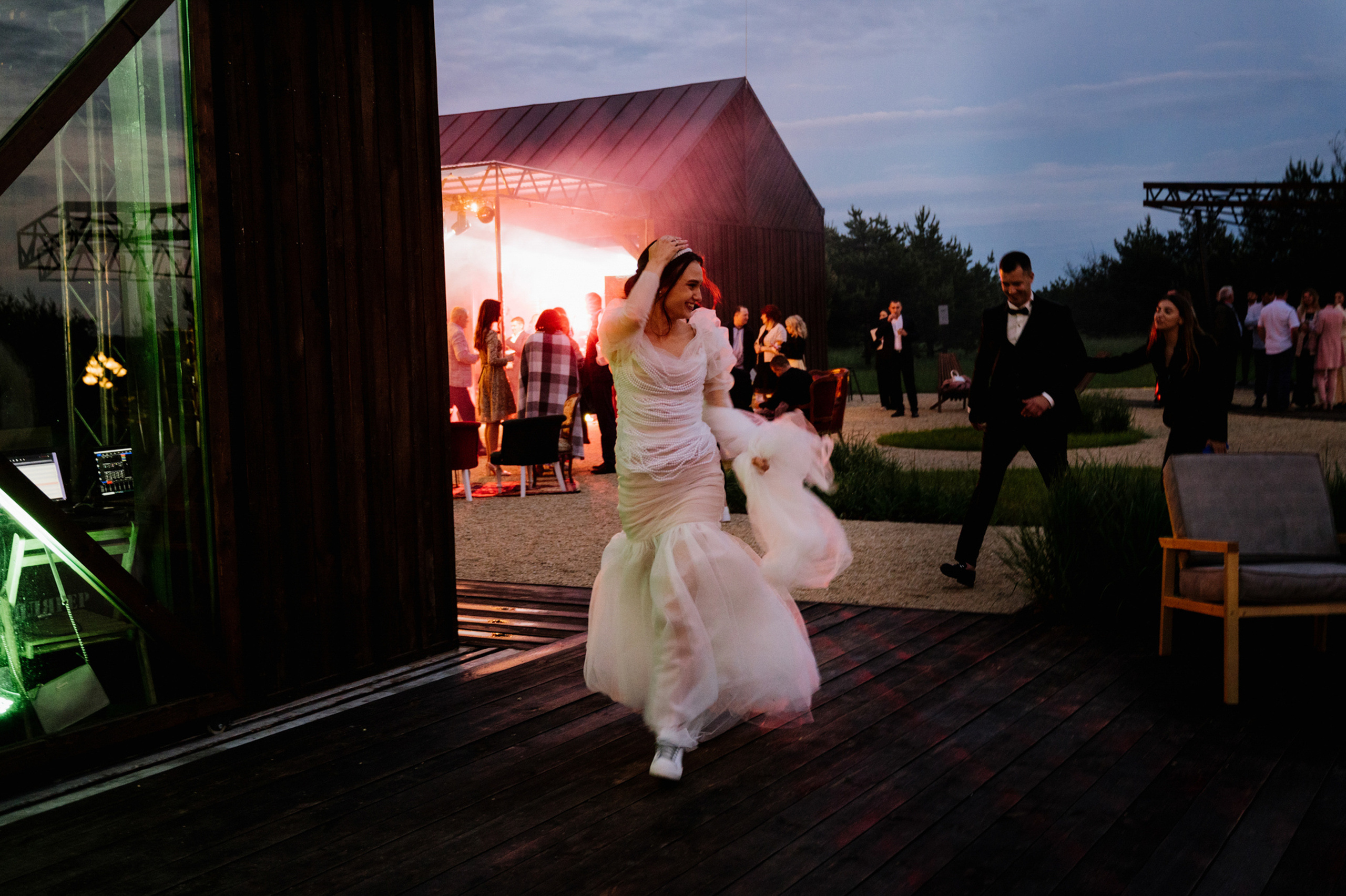 a bride and groom are dancing on a deck