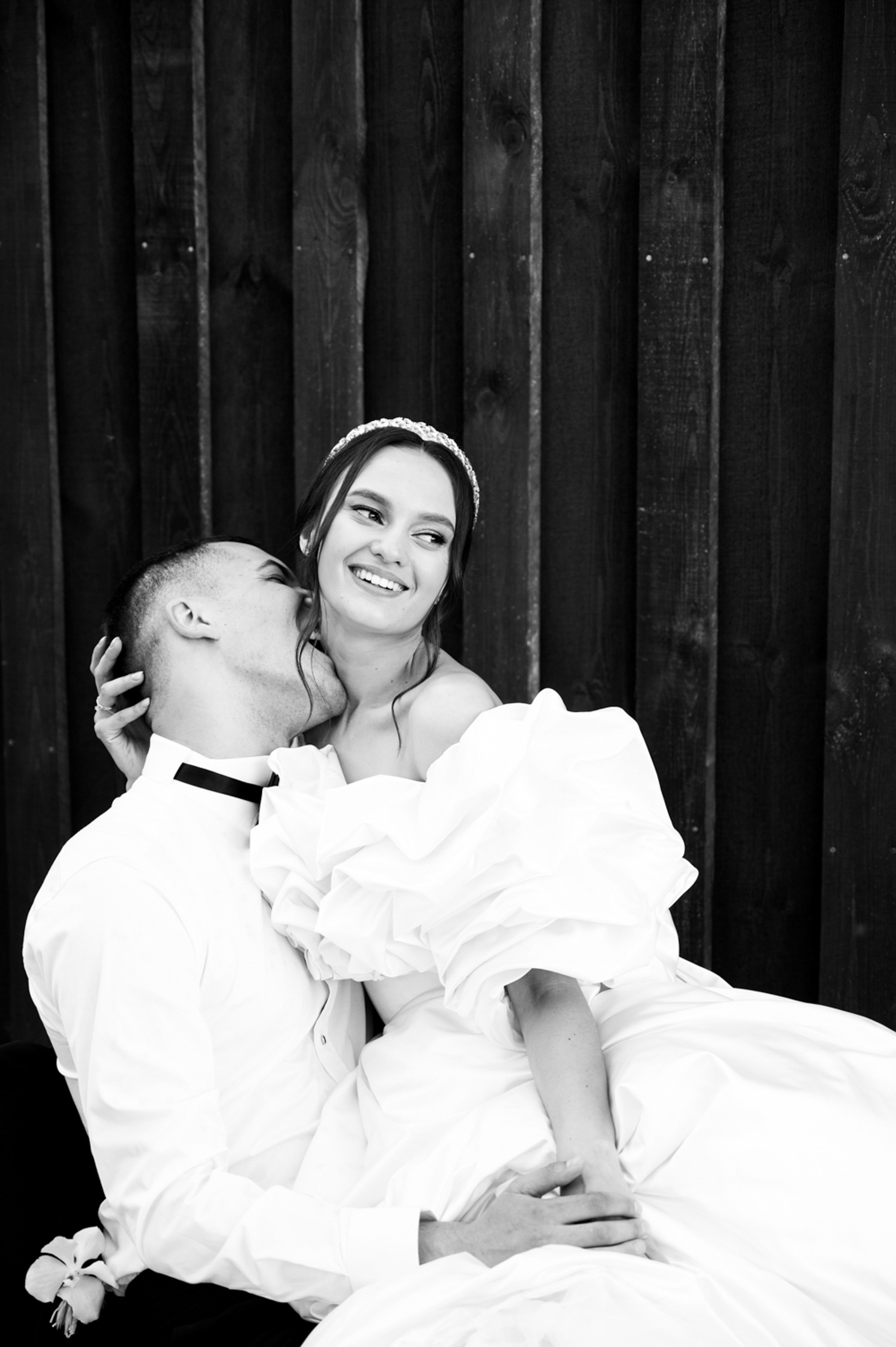 a bride and groom sitting on a bench