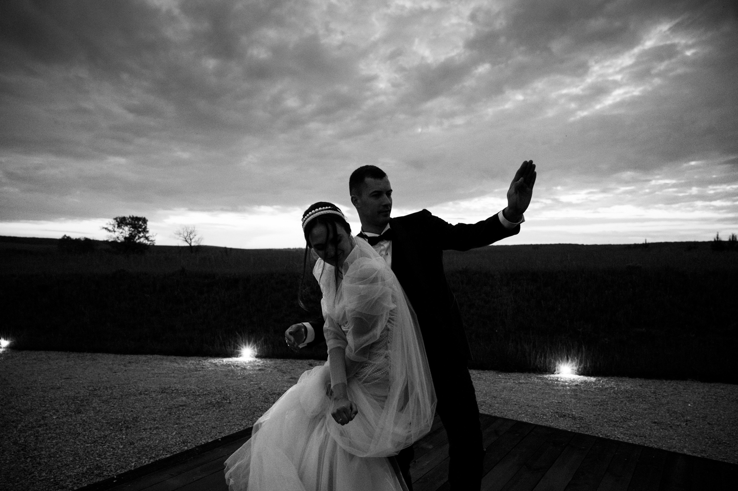 a bride and groom pose for a photo in the evening