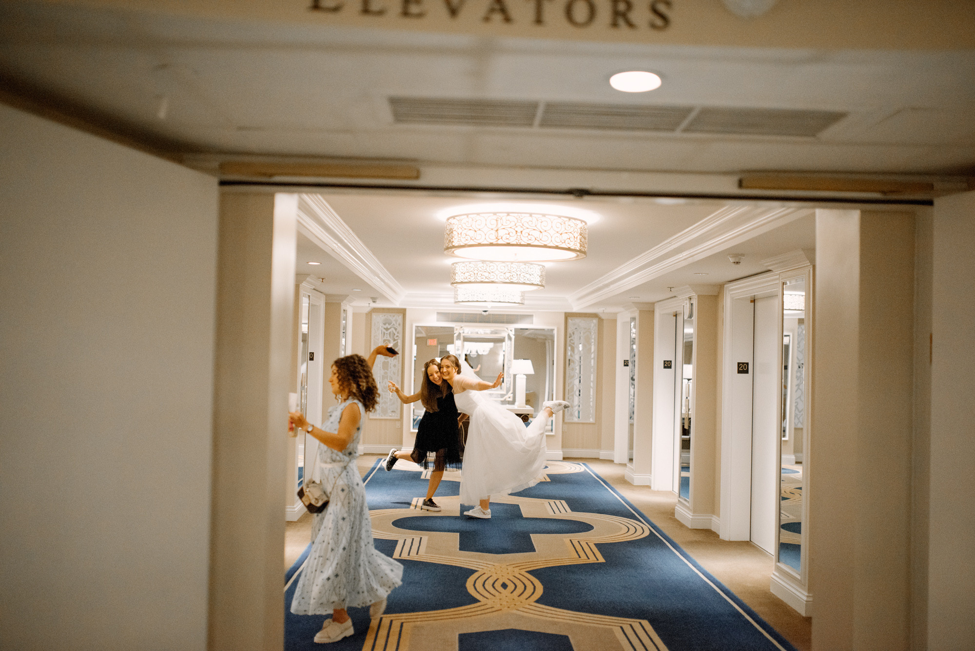 a bride and her maid walk down the hall
