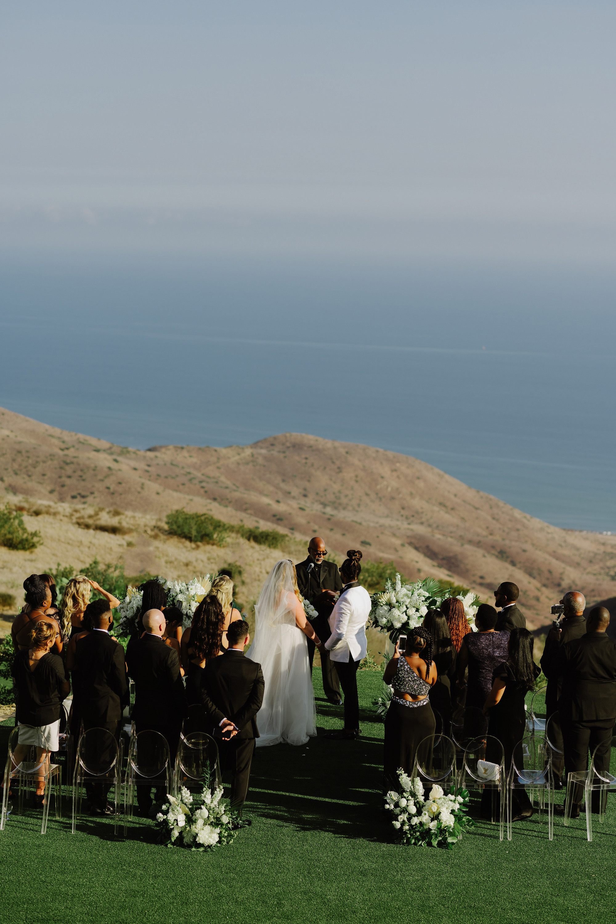 a wedding ceremony on the lawn overlooking the ocean