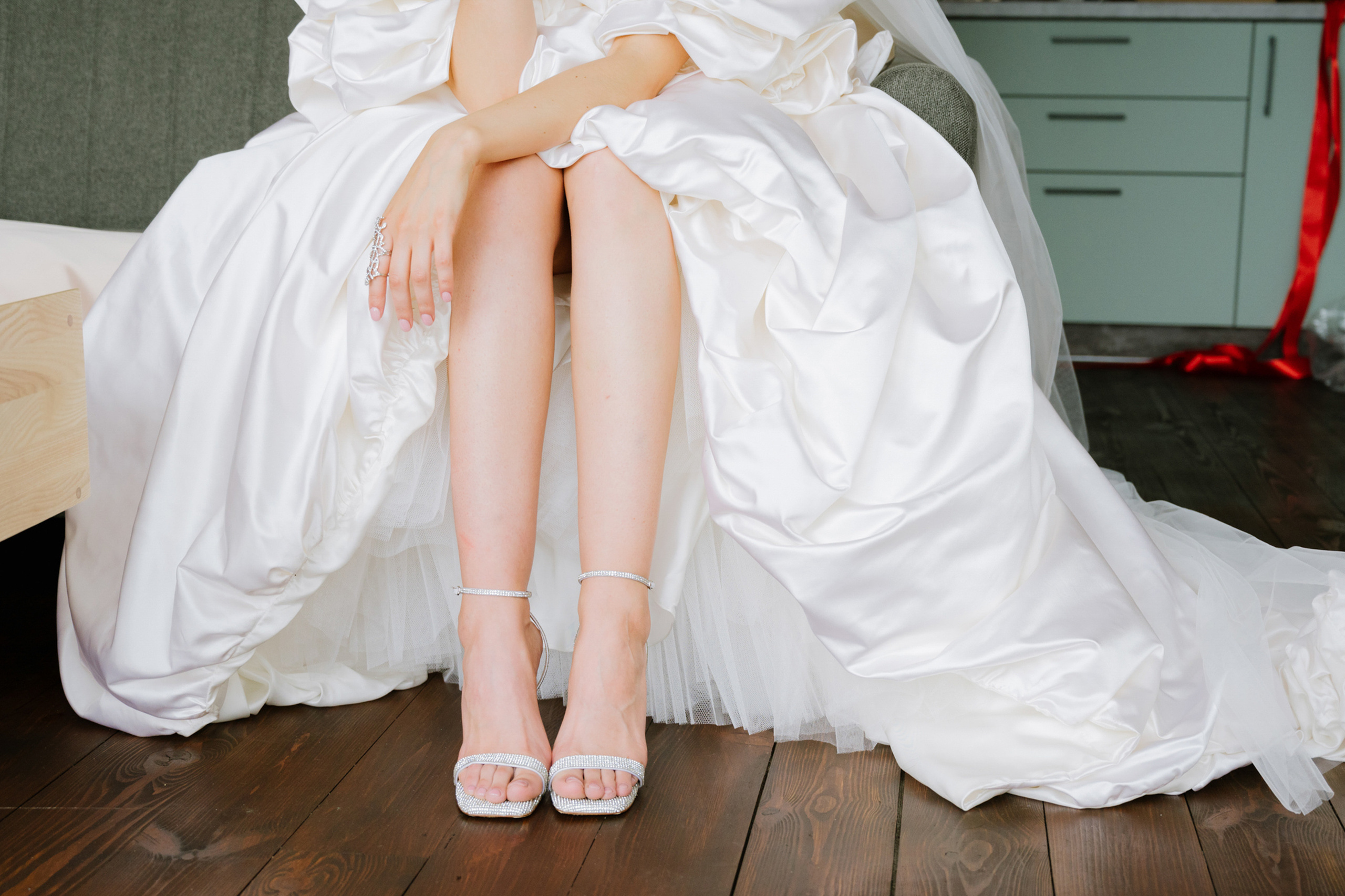 a bride sitting on a bed wearing a wedding dress