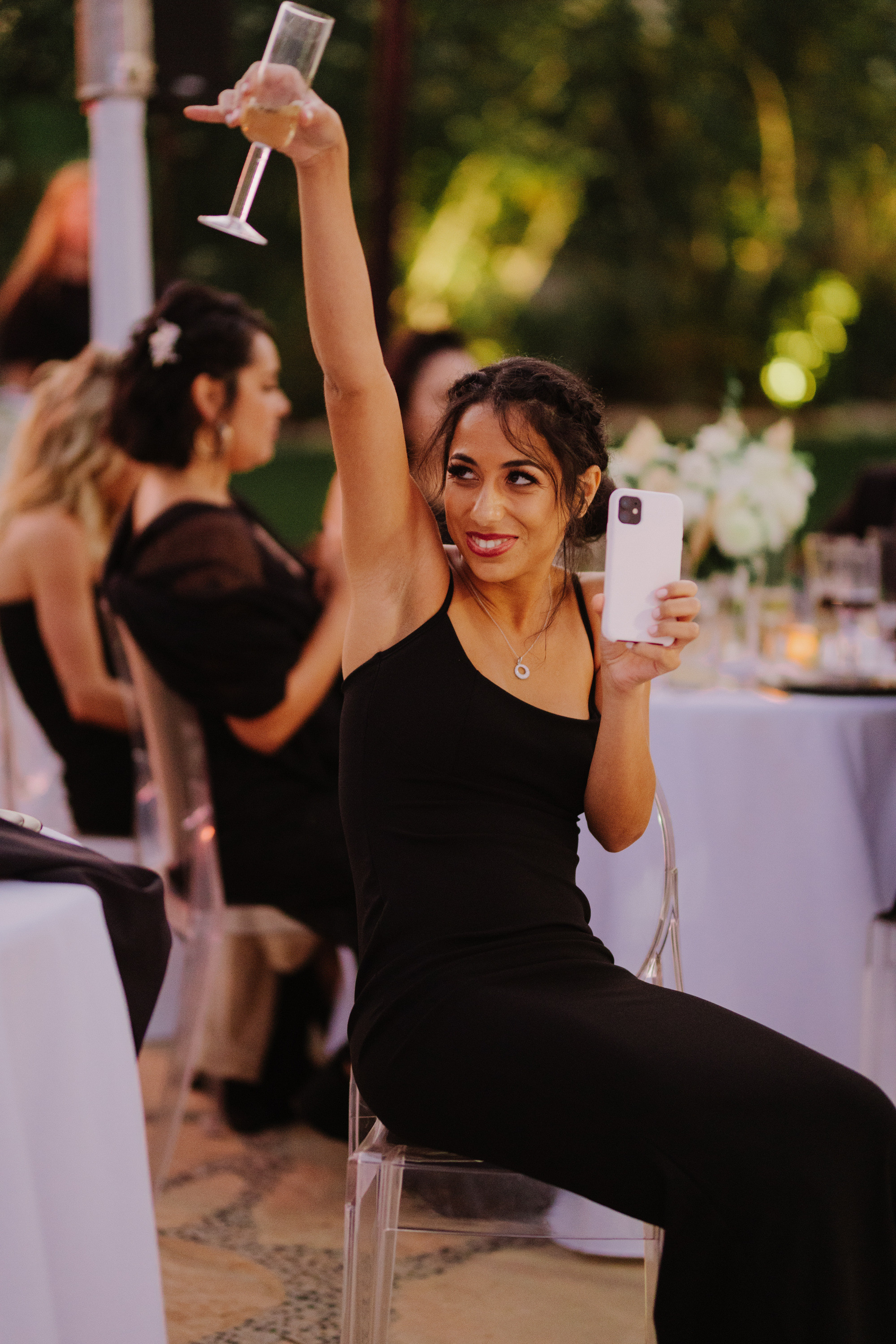 a woman in a black dress is holding a cell