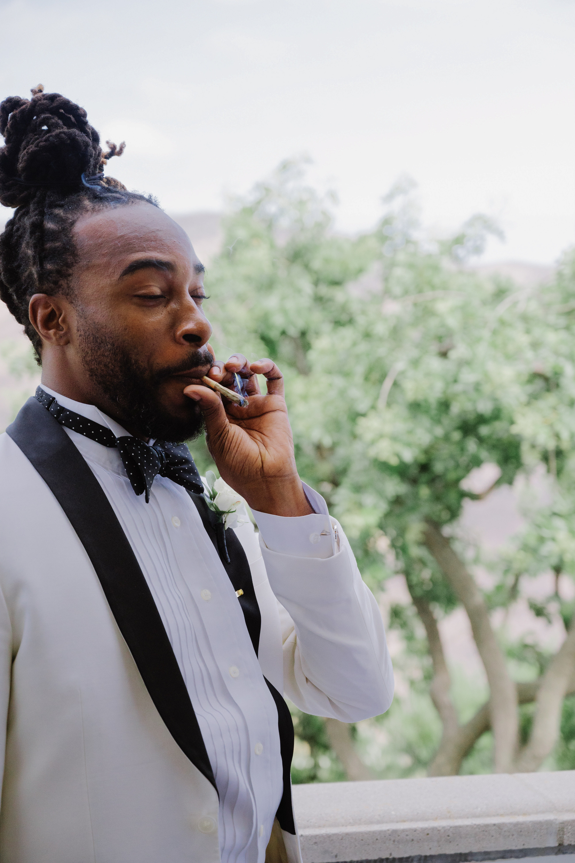 a man in a tuxed suit smoking a cigarette