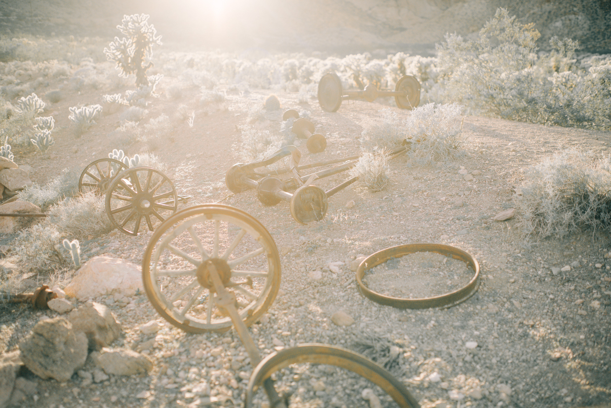 a bunch of old wooden wheels on a dirt road