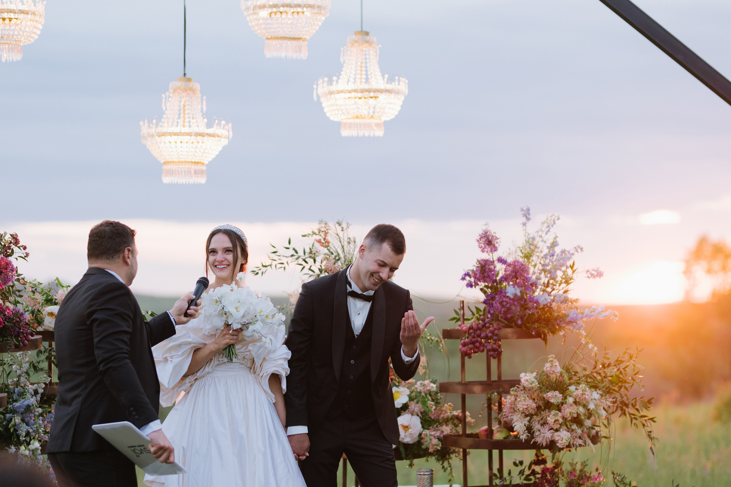 a bride and groom are standing under a wedding arch