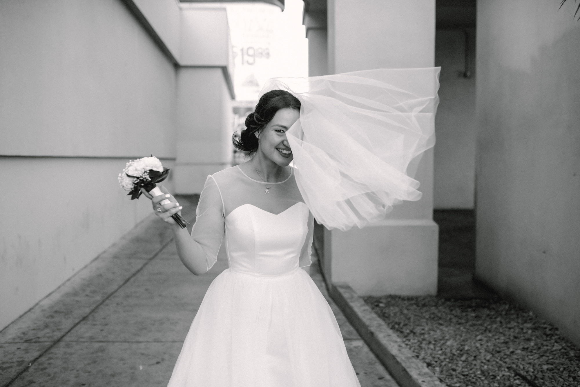 a bride in a white dress holding a flower