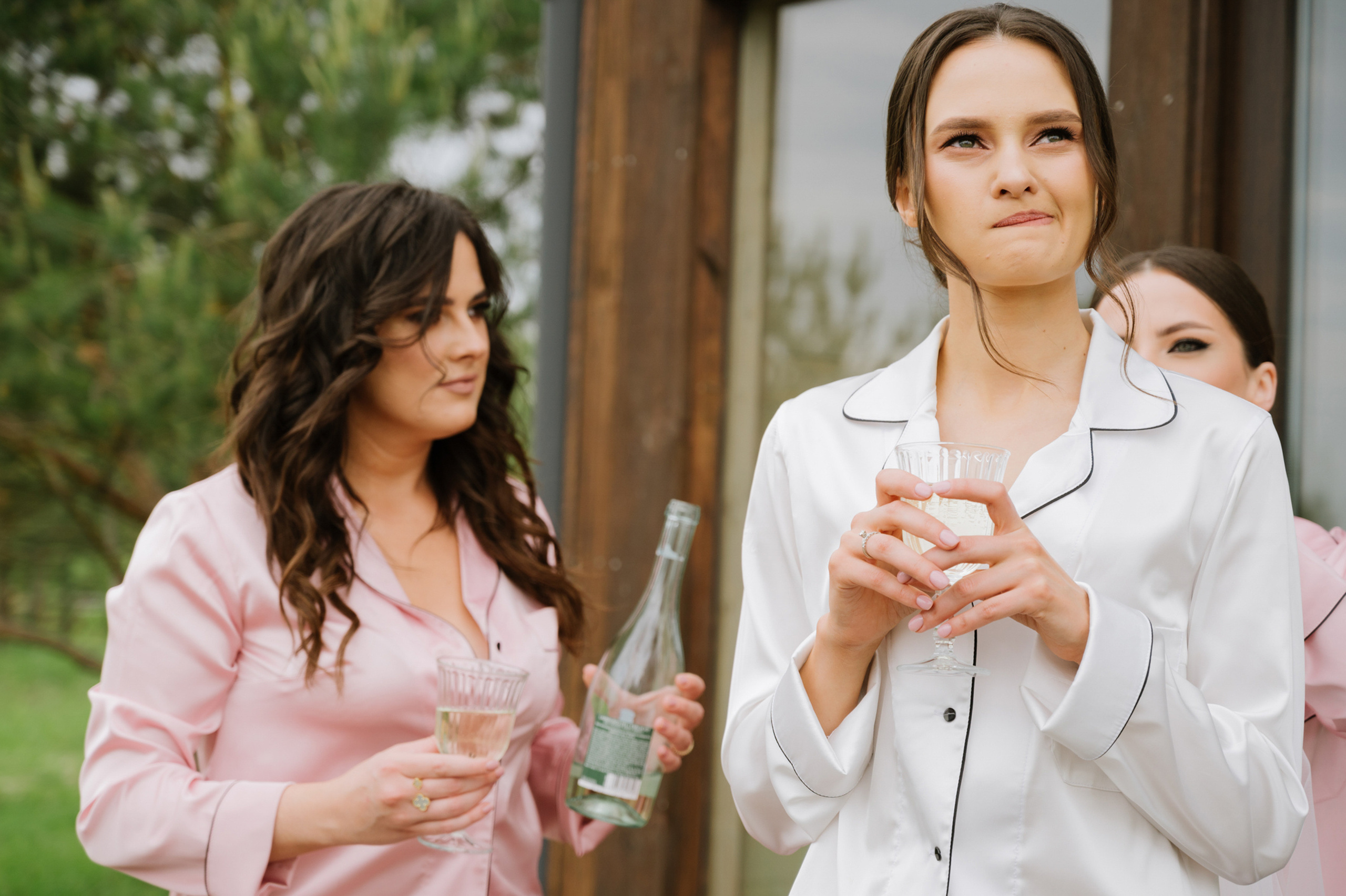two women in pink robes holding wine glasses
