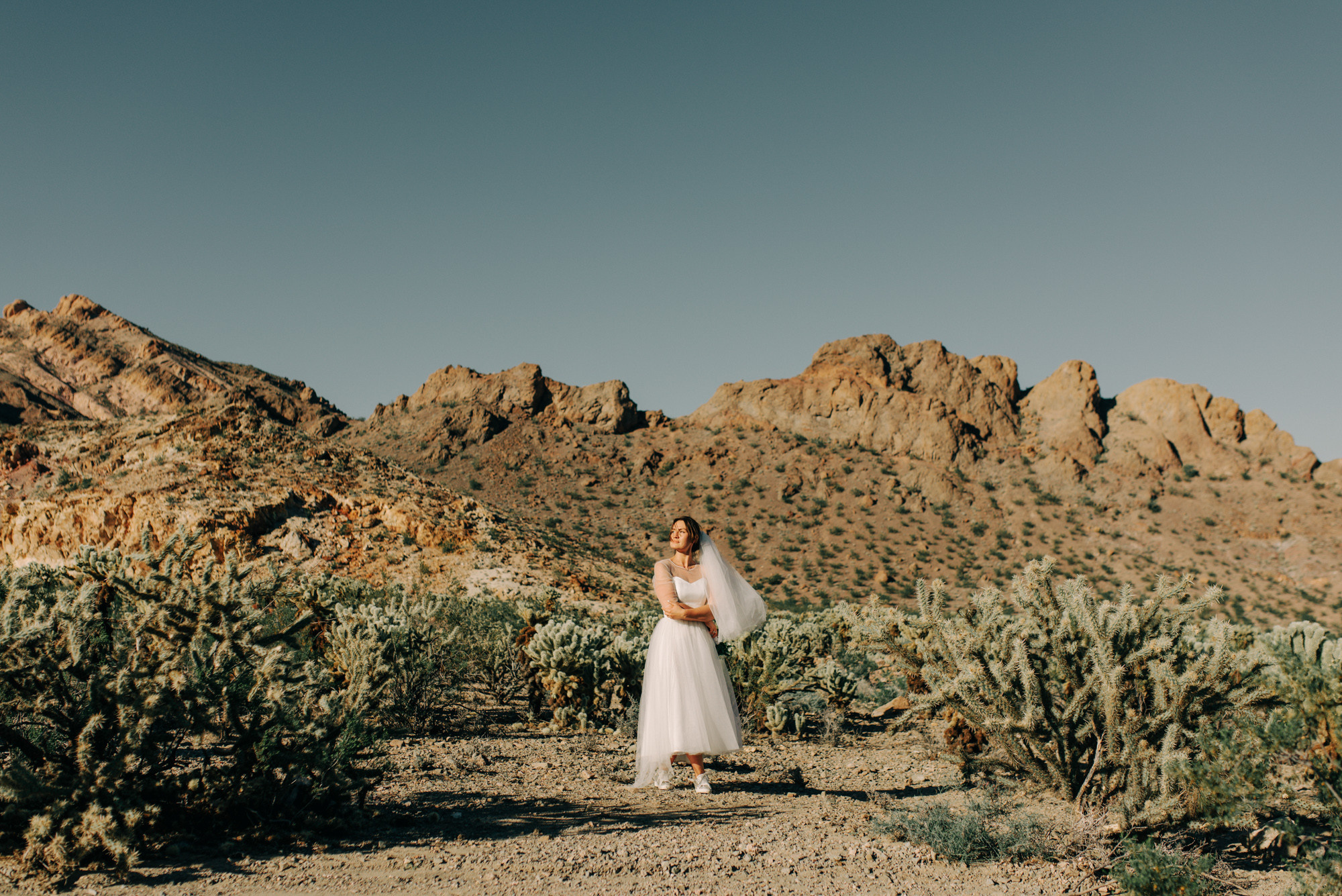 a woman in a white dress standing in a desert