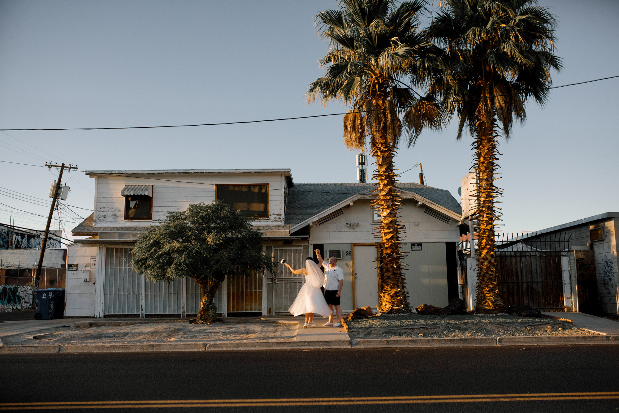 a woman in a white dress is walking down the street