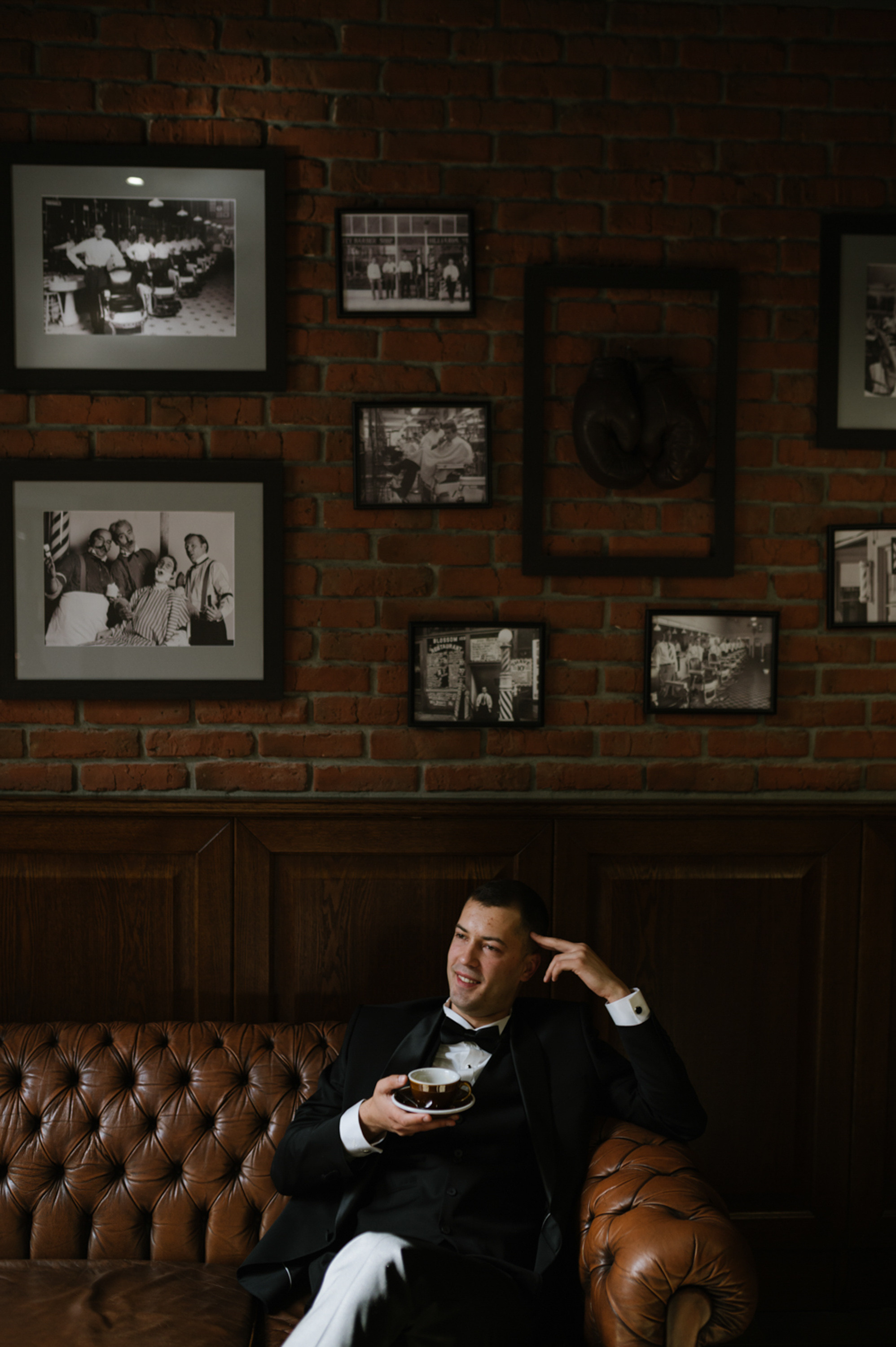a man in a tuxed suit sitting on a couch