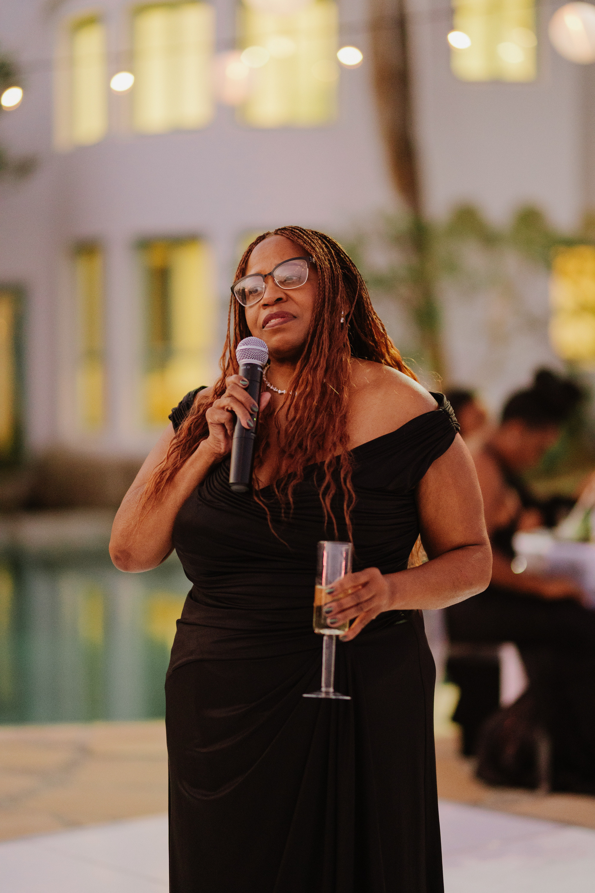 a woman in a black dress holding a microphone