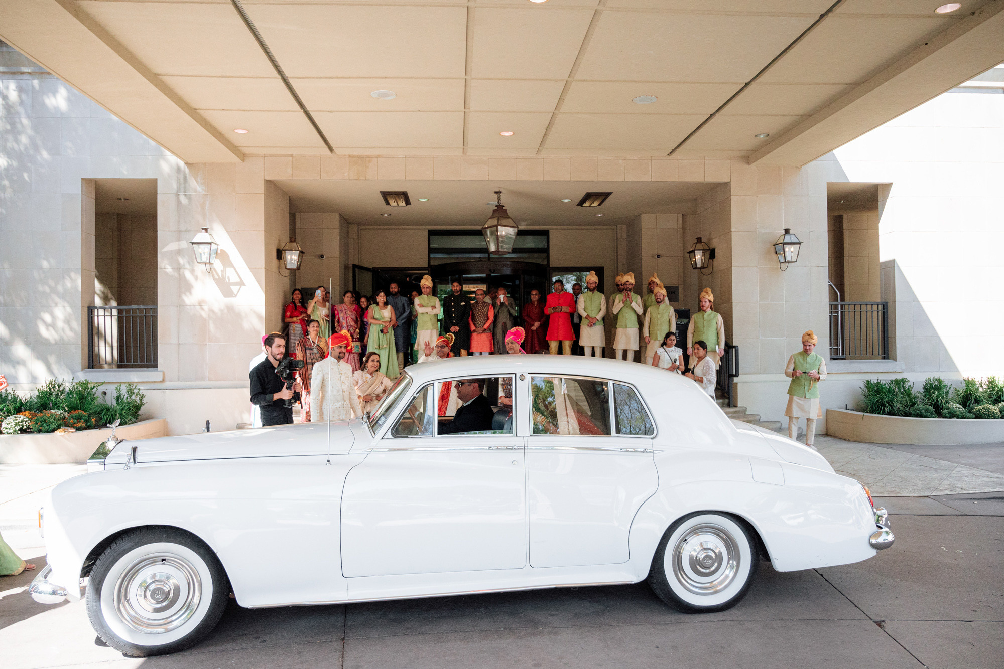 a group of people standing around a white car