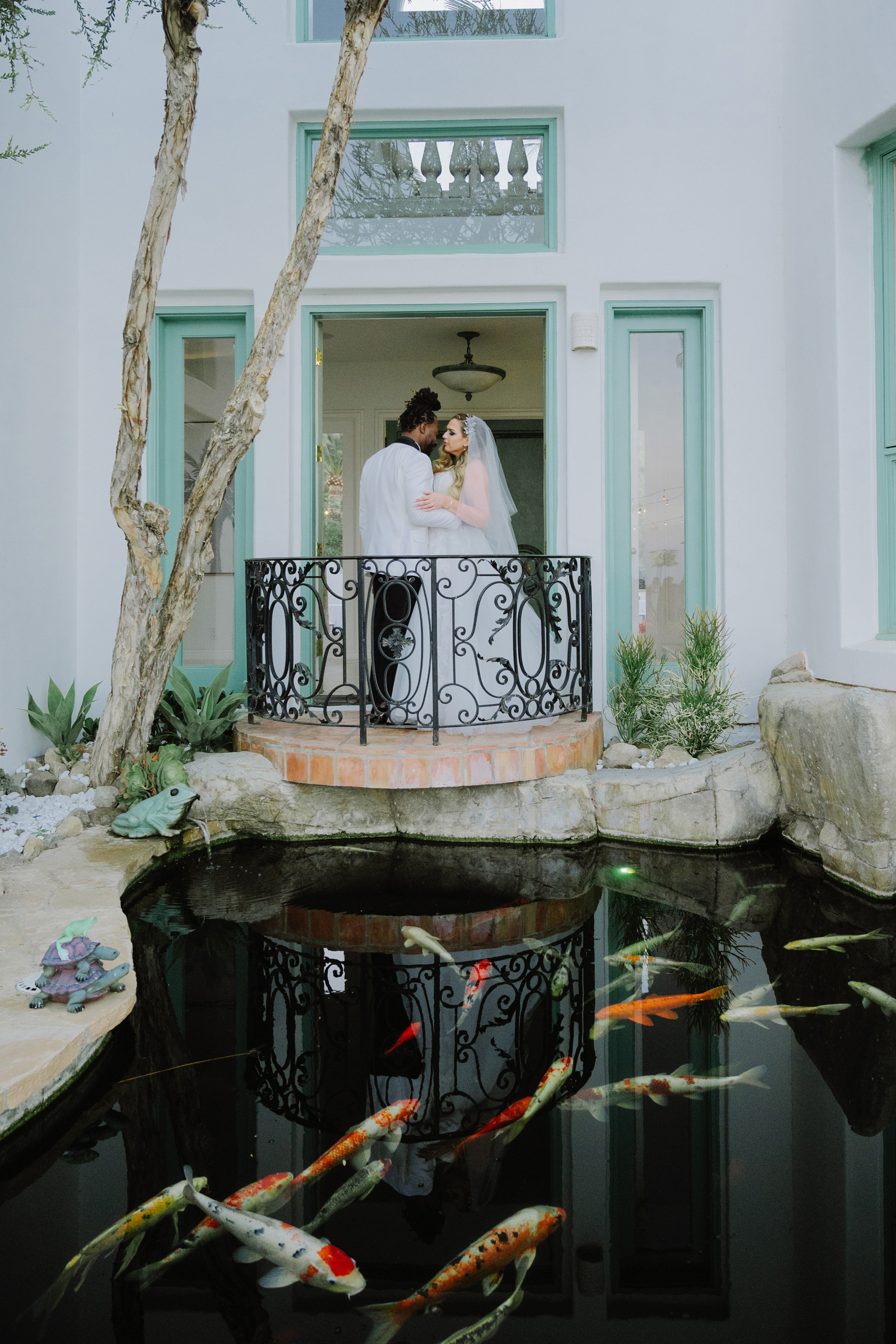 a couple kissing on a balcony with koi fish