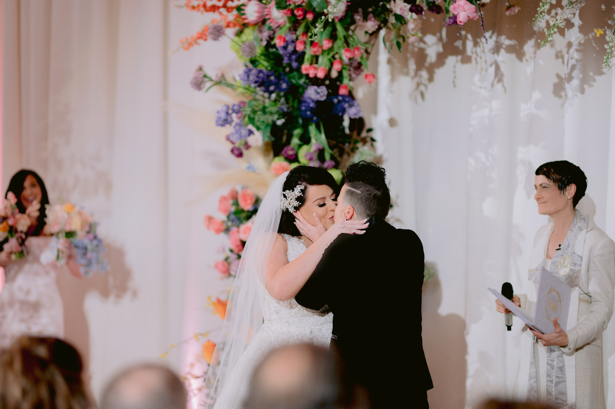 a bride and groom kiss during their wedding ceremony