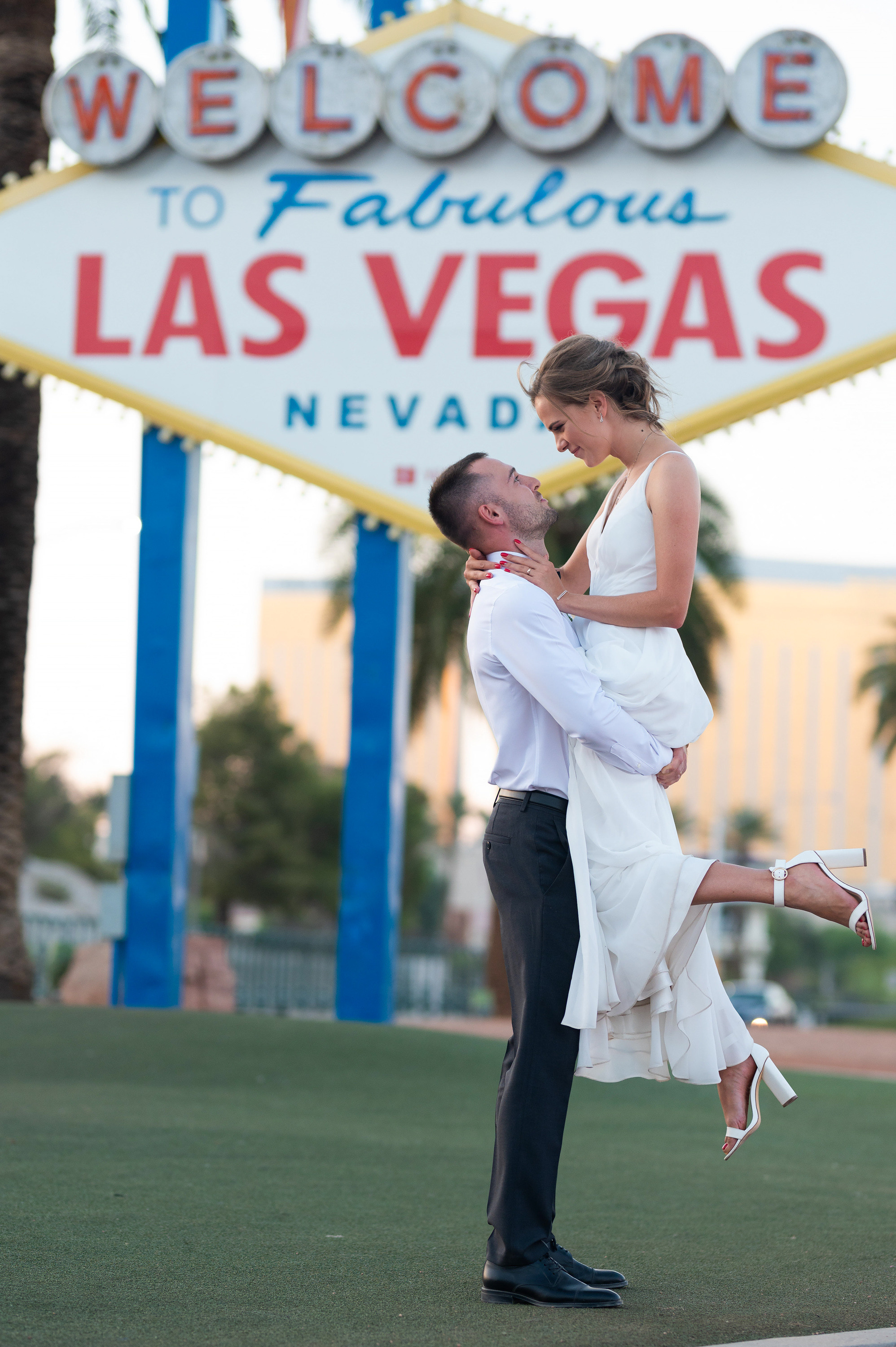 a man and woman are dancing in front of a welcome sign