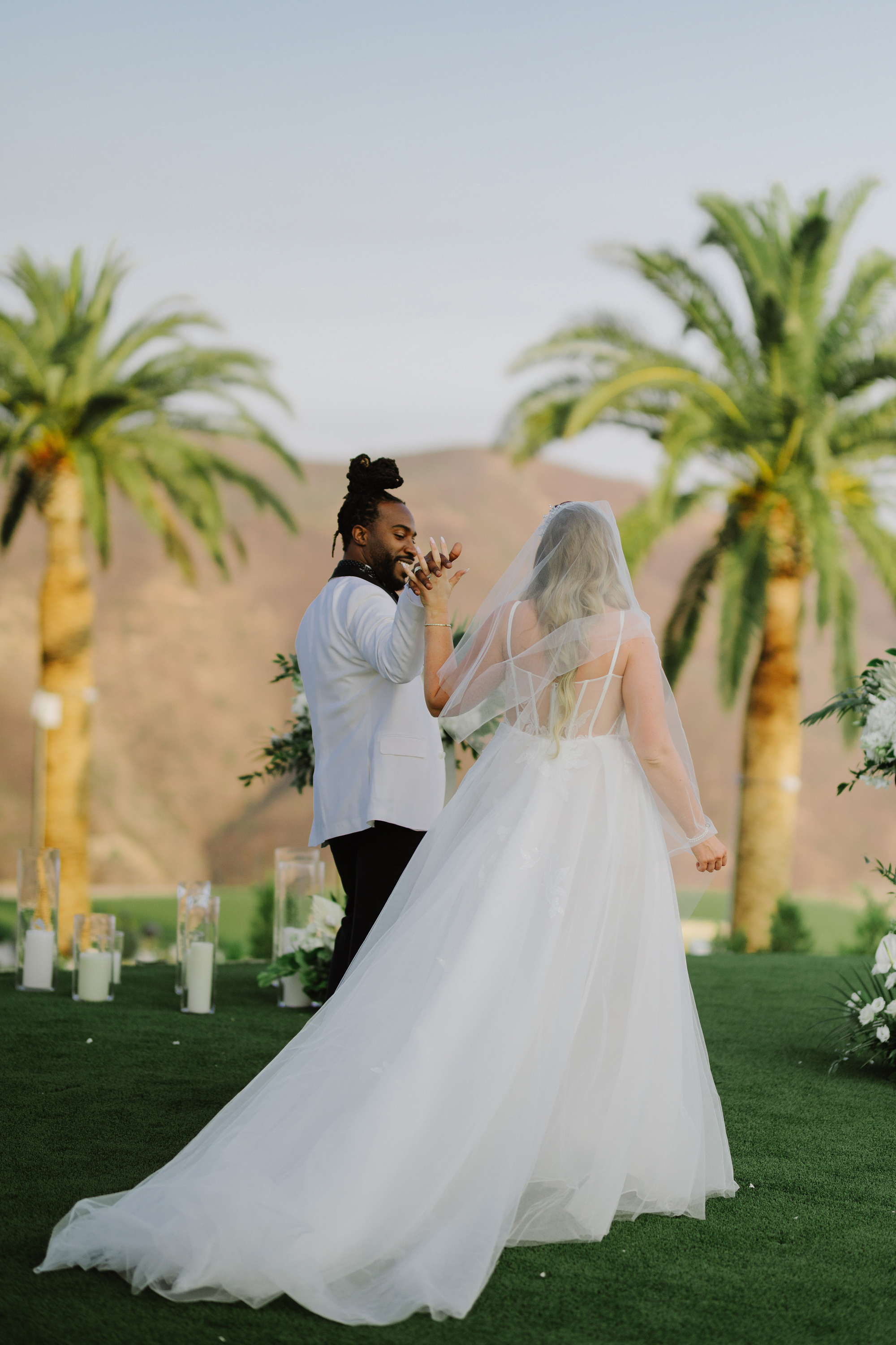 a bride and groom are standing in front of palm trees