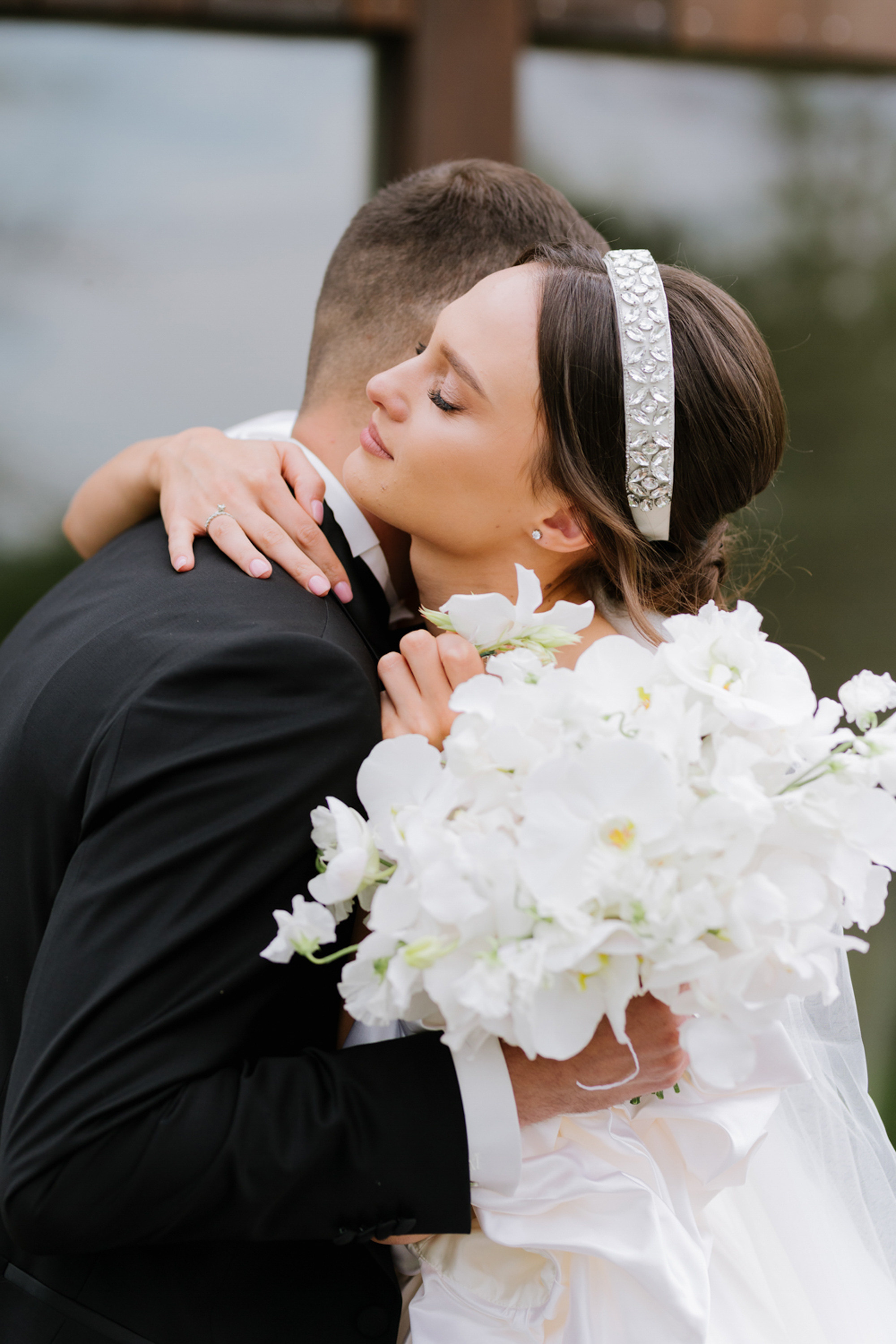 a bride and groom kissing in front of a wooden fence