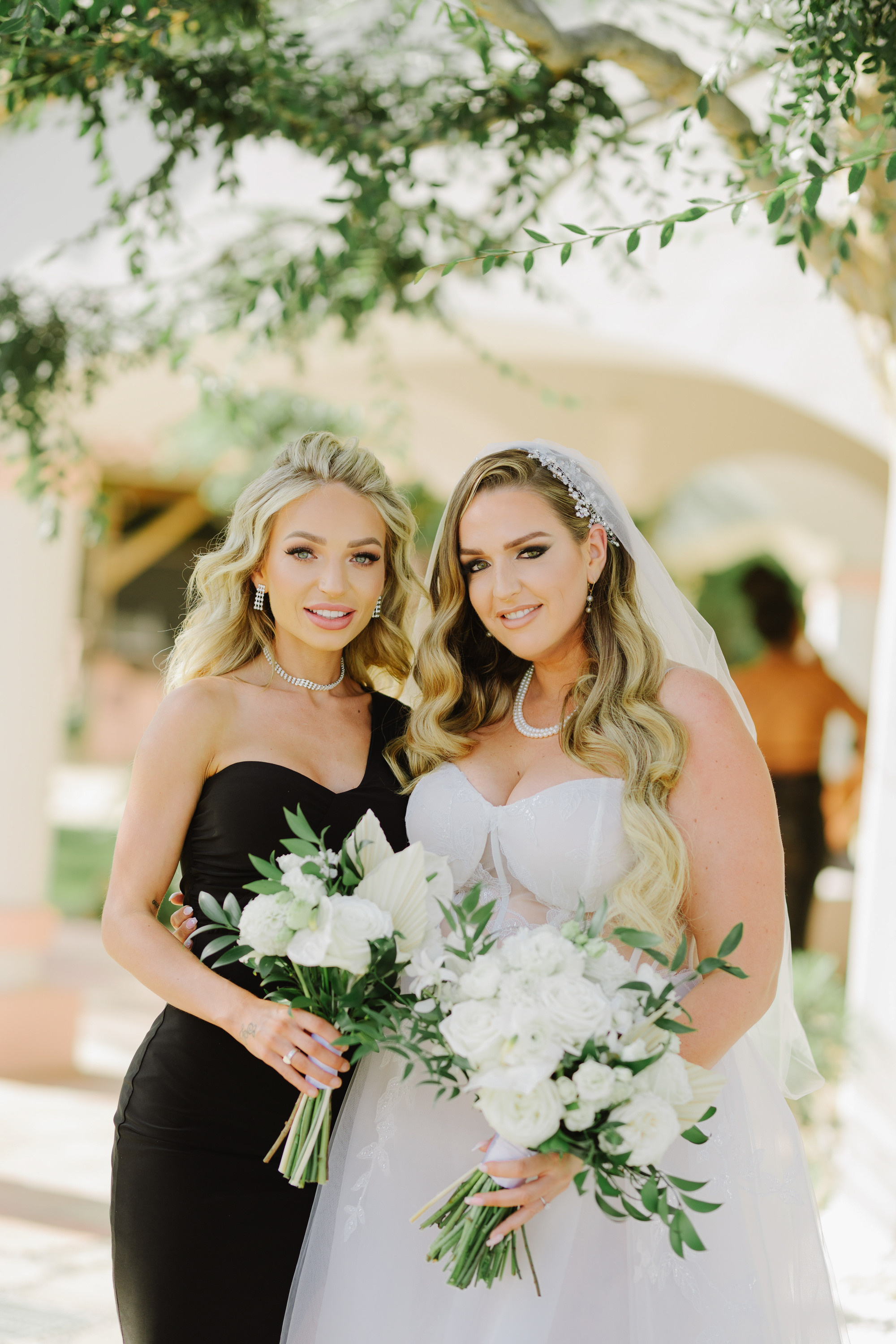 two brides in black dresses and white bouquets