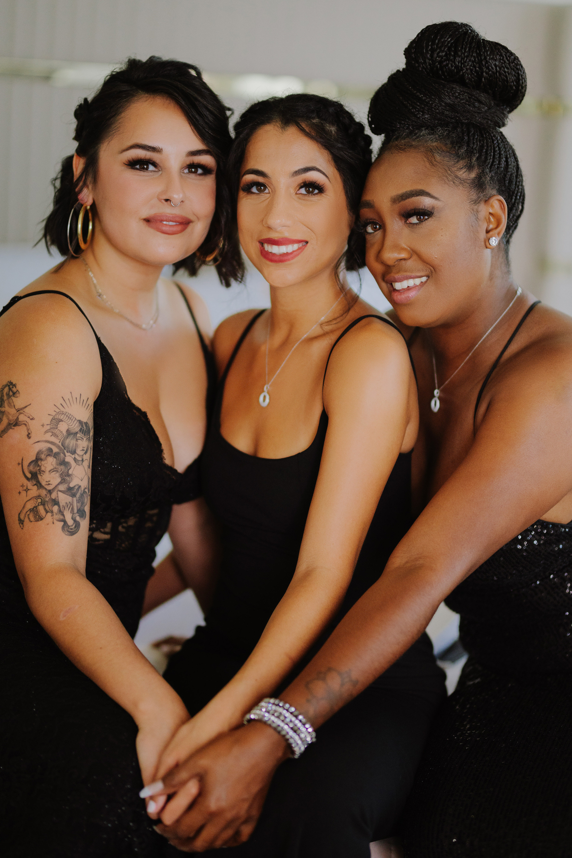 three women in black dresses posing for a photo