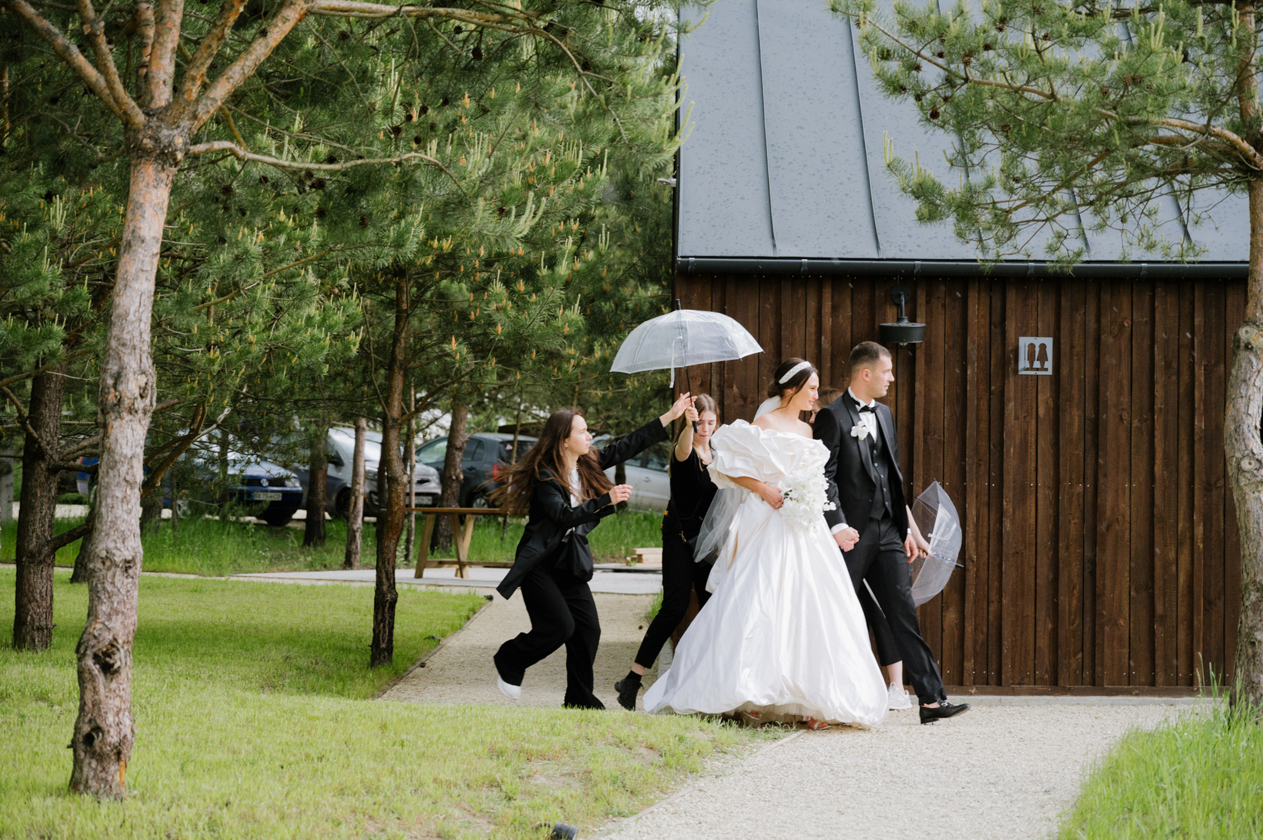 a bride and groom walking in the rain