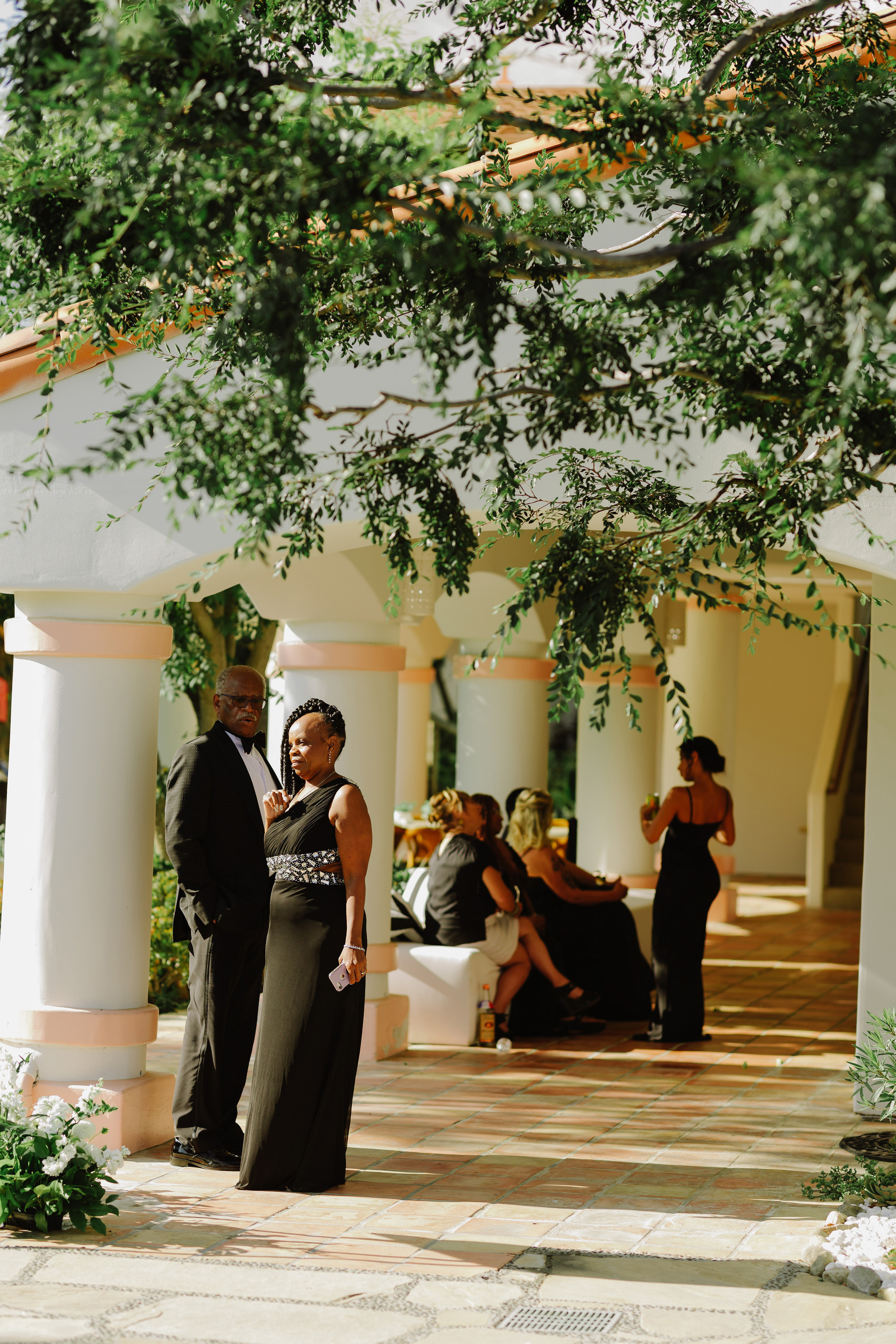 a couple standing under a tree in a courtyard