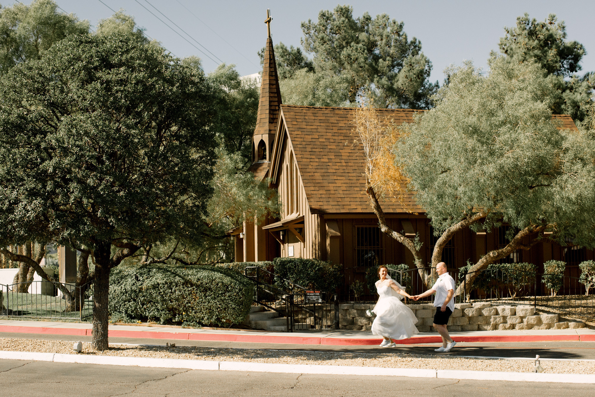 a bride and groom are walking down the street