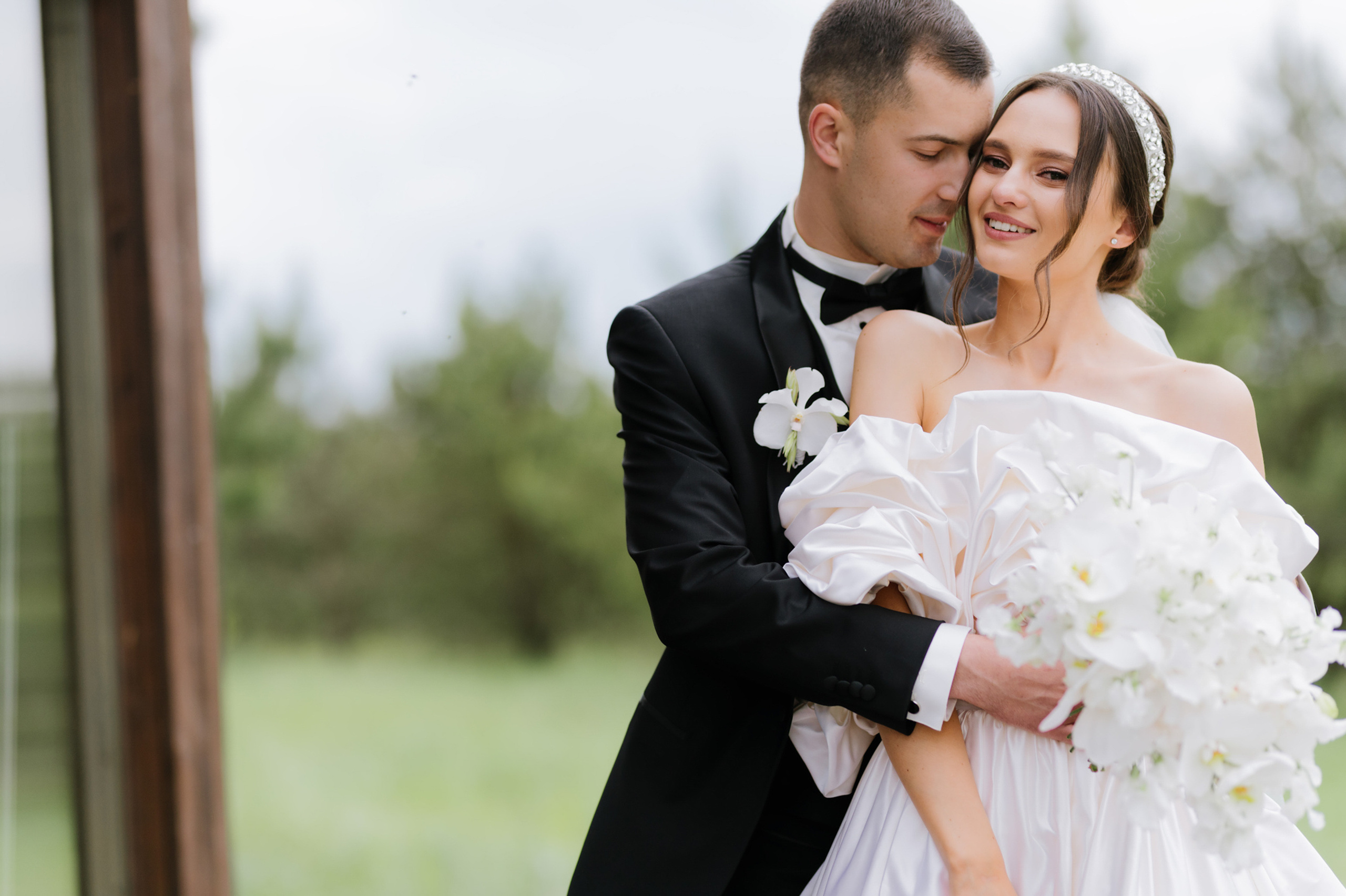 a bride and groom hugging in the grass