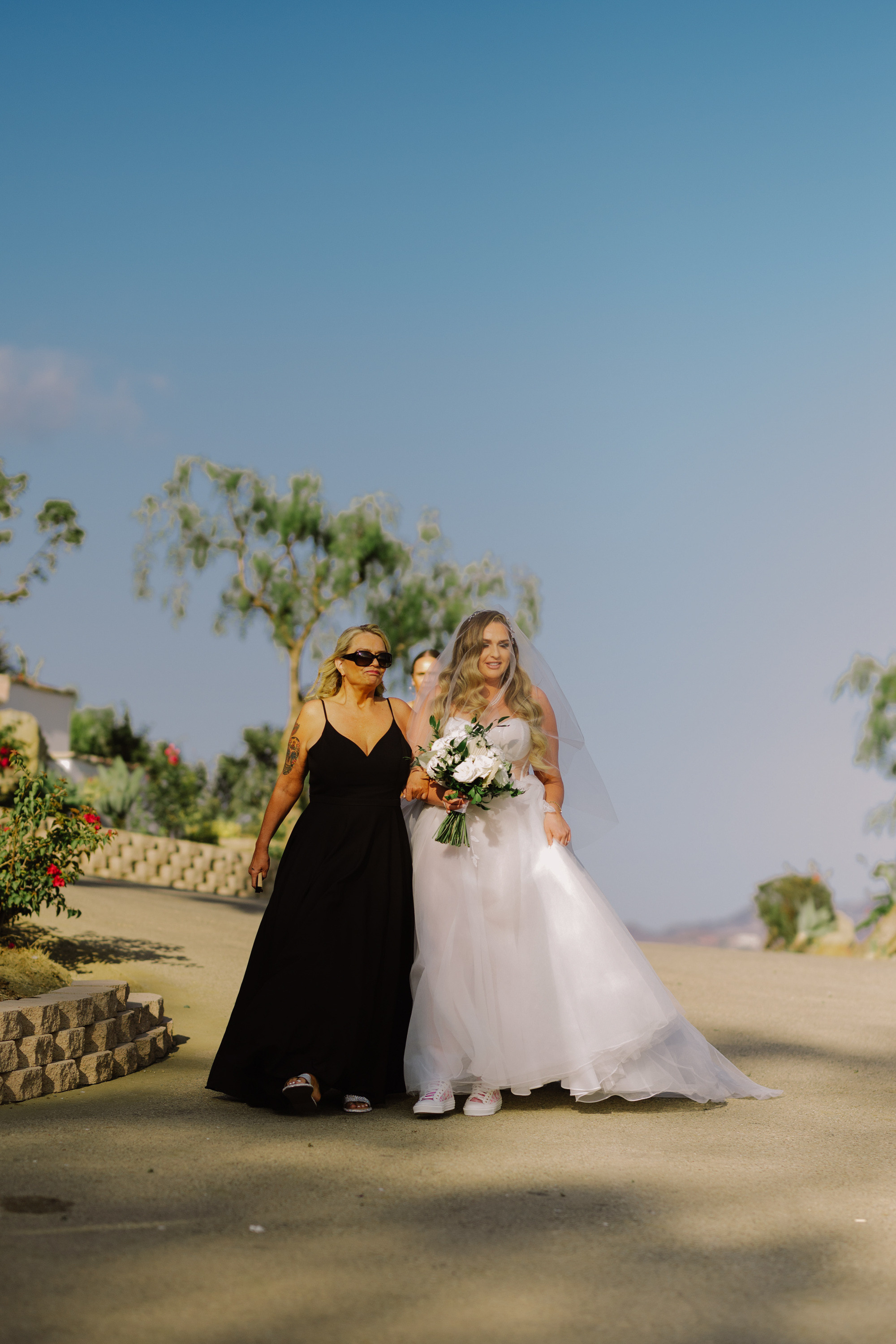 a bride and her mother walking down the aisle