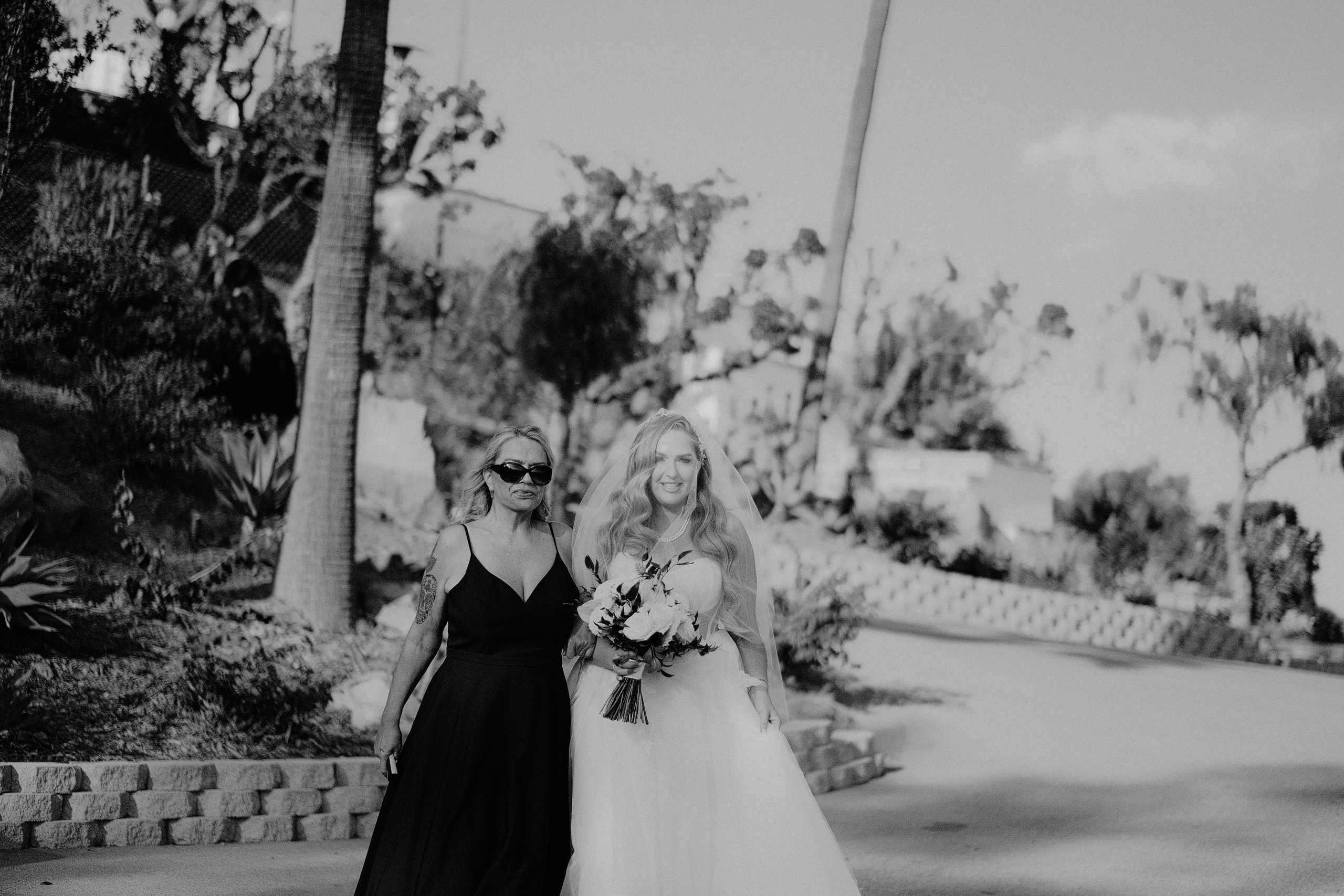 a bride and her mother walking down the street