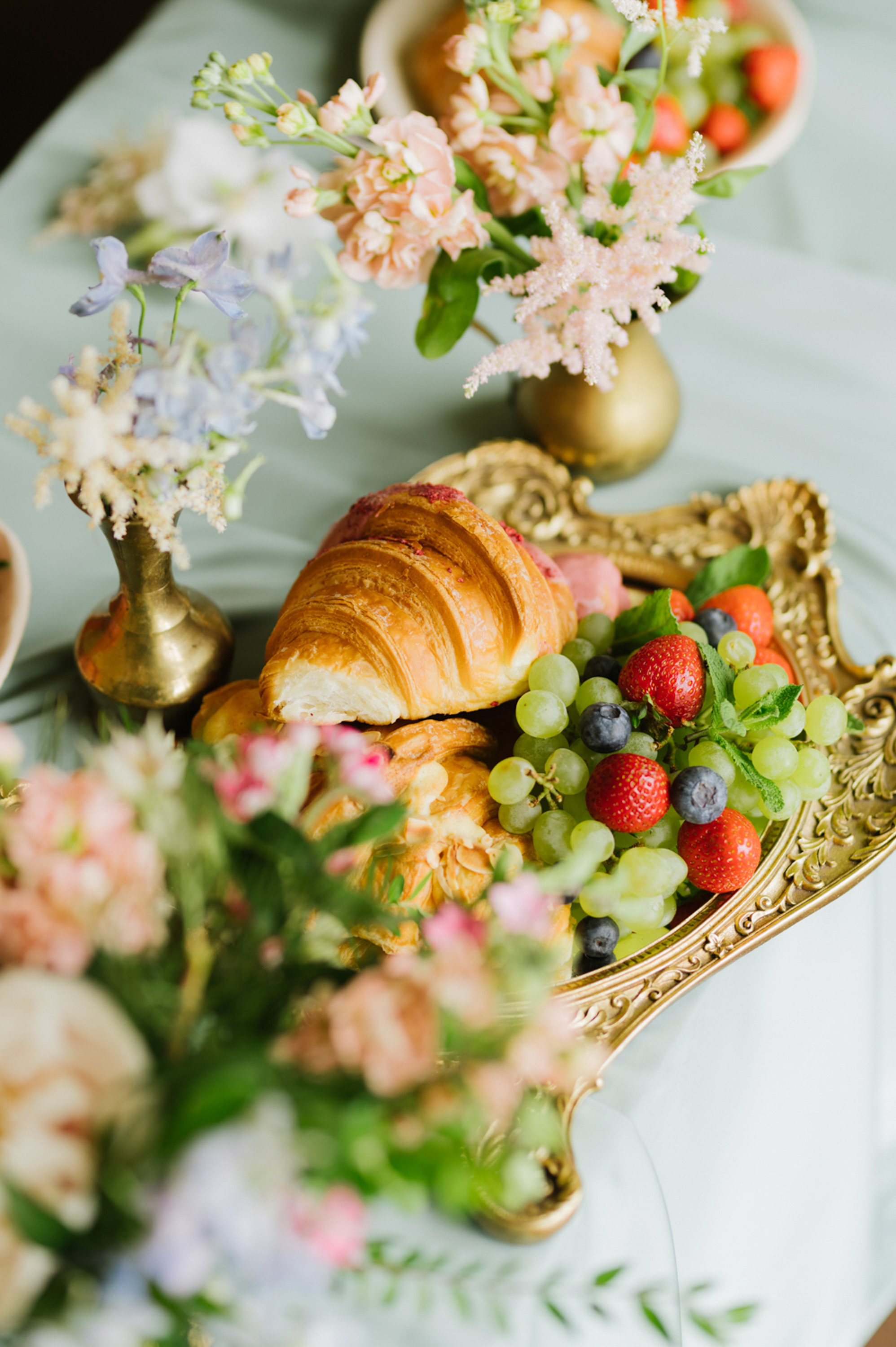 a table with a tray of fruit and flowers