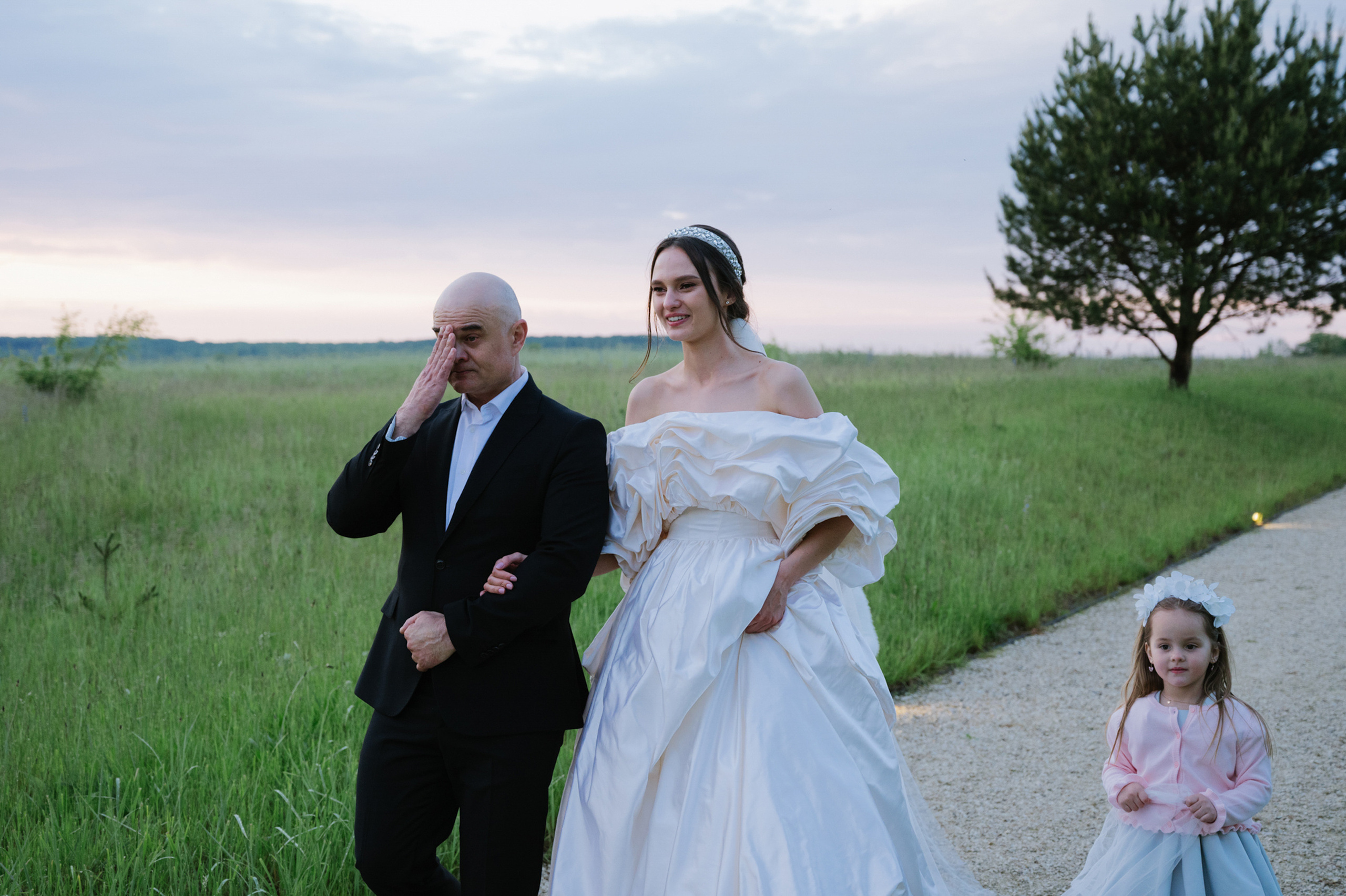 a bride and groom walking down a path