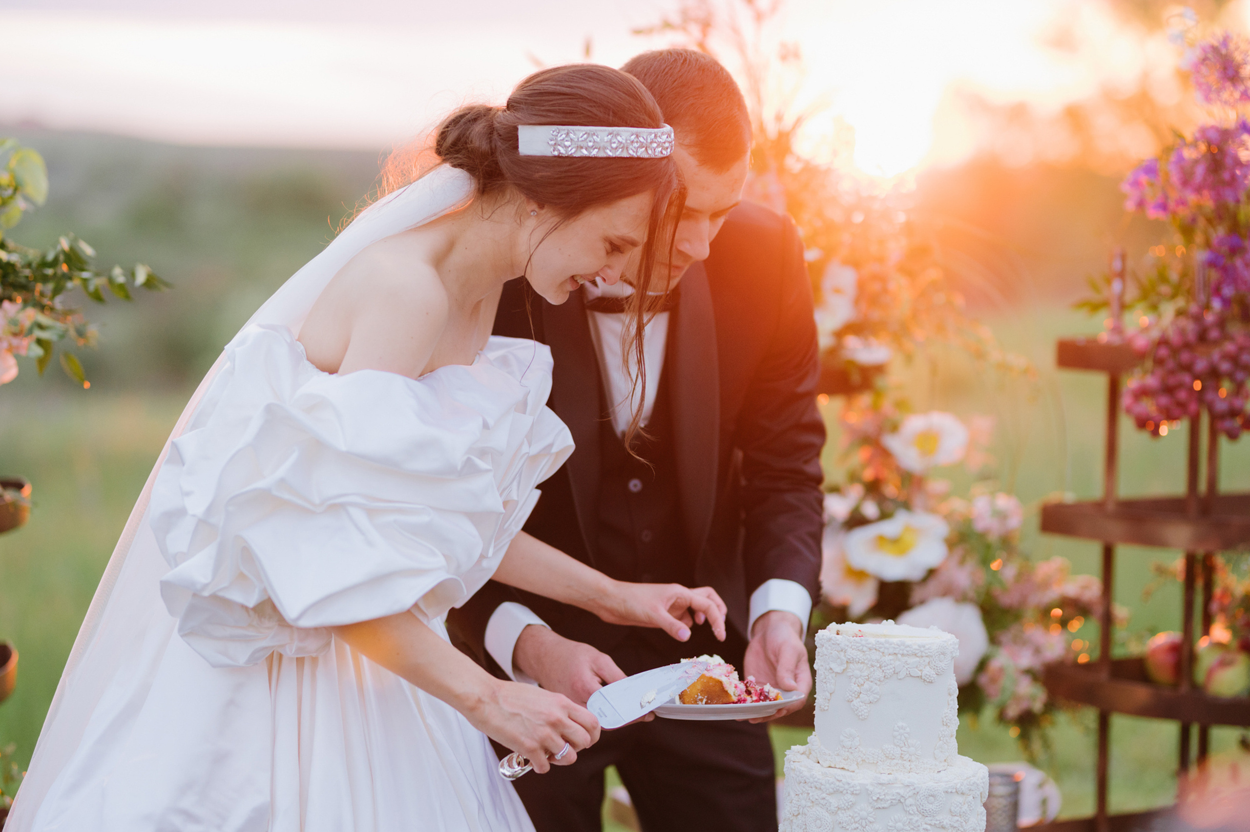 a bride and groom cutting a wedding cake
