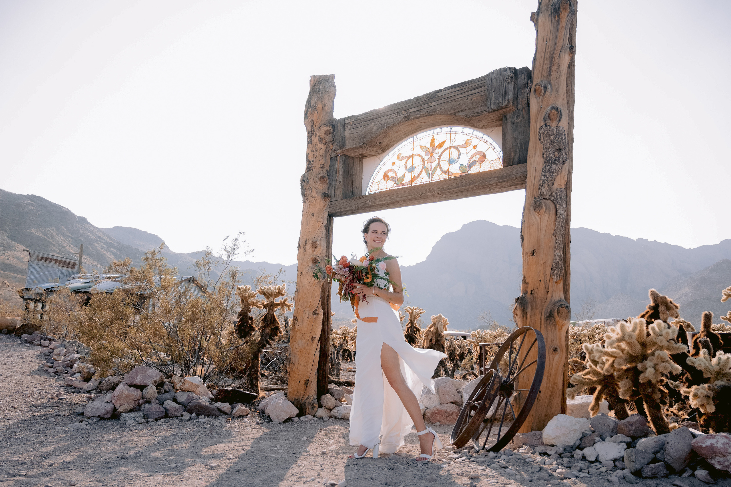 a woman in a white dress standing in front of a wooden frame