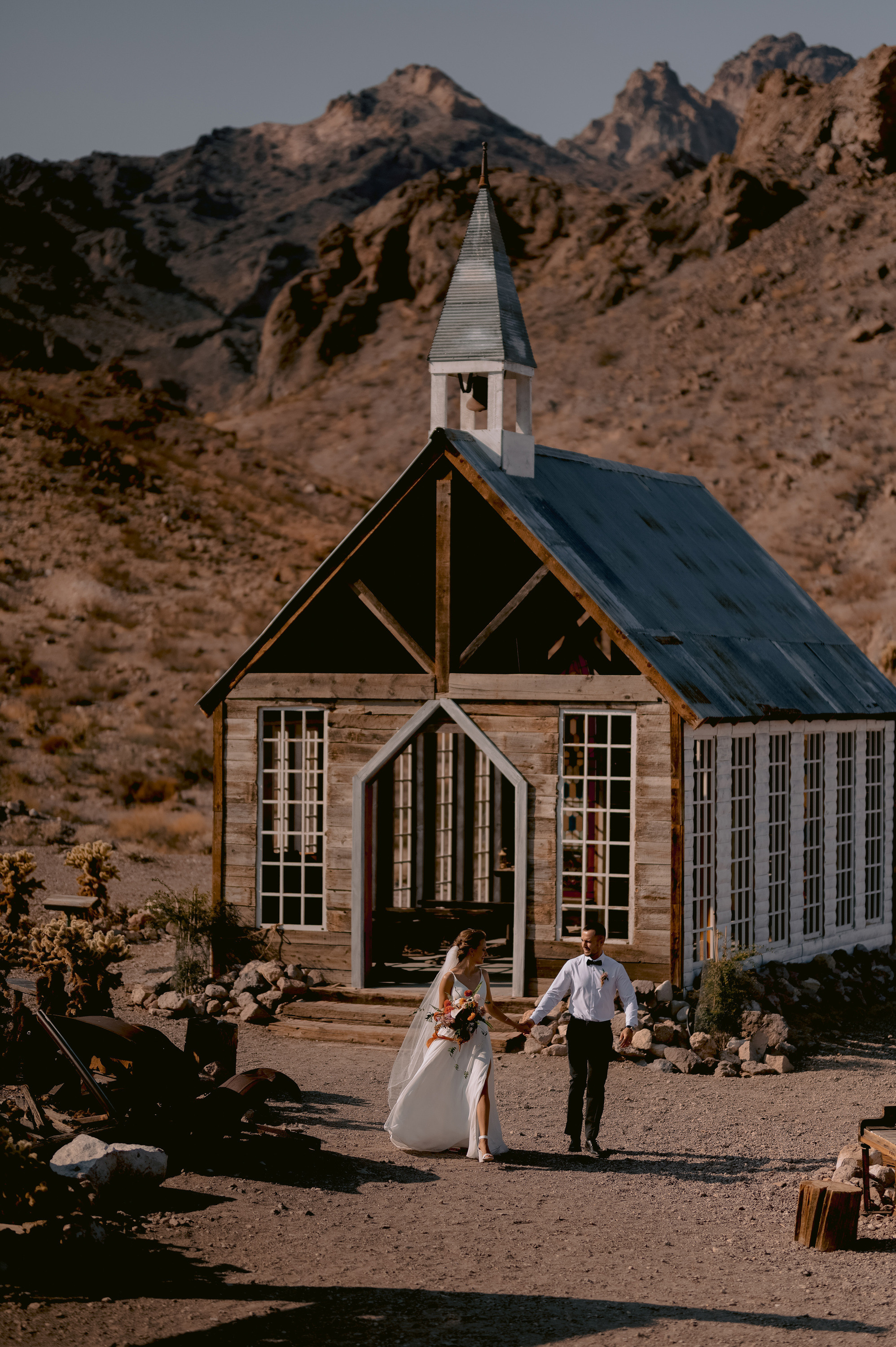 a couple walking towards a church in the desert