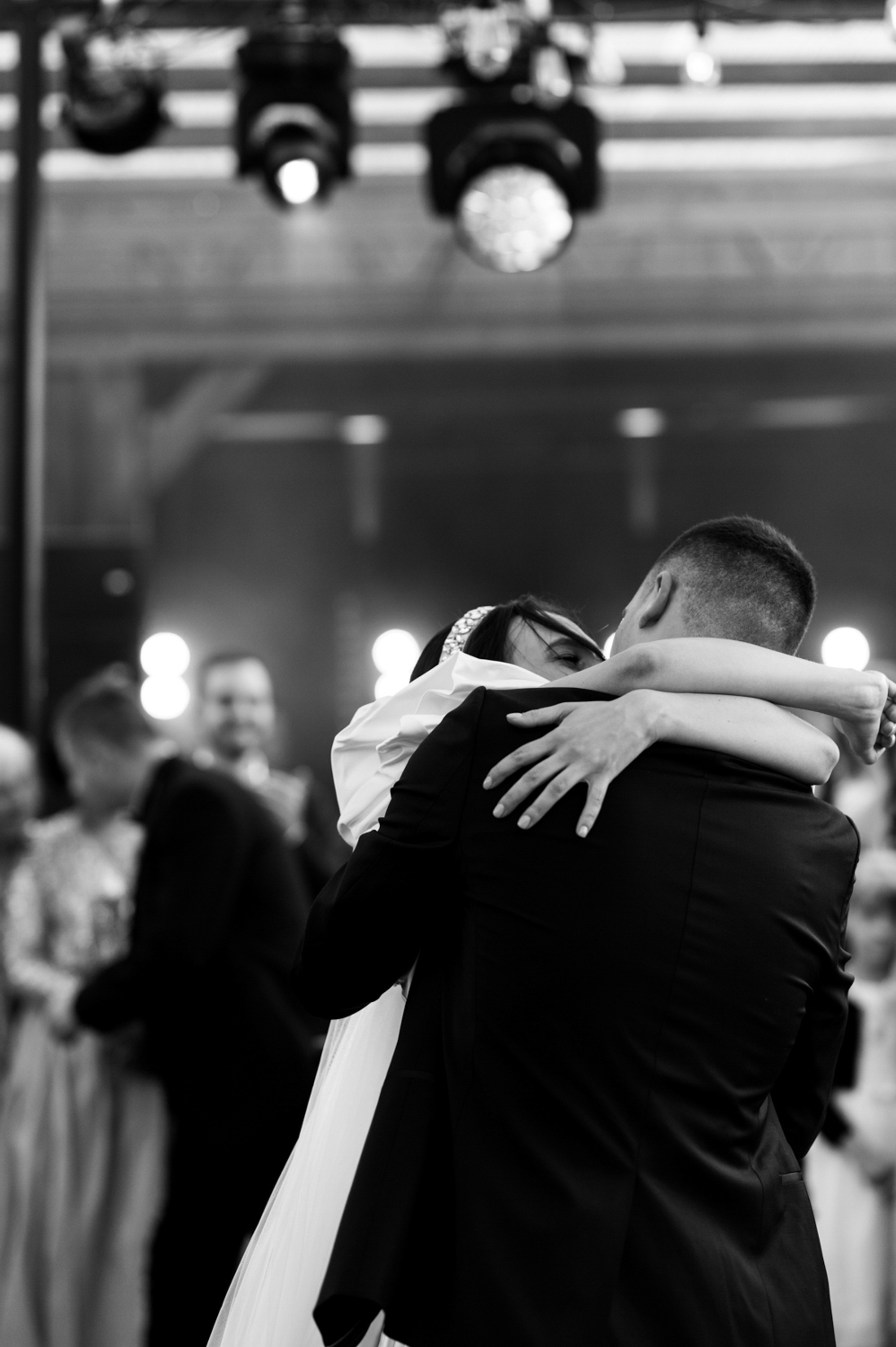a bride and groom hug at their wedding reception